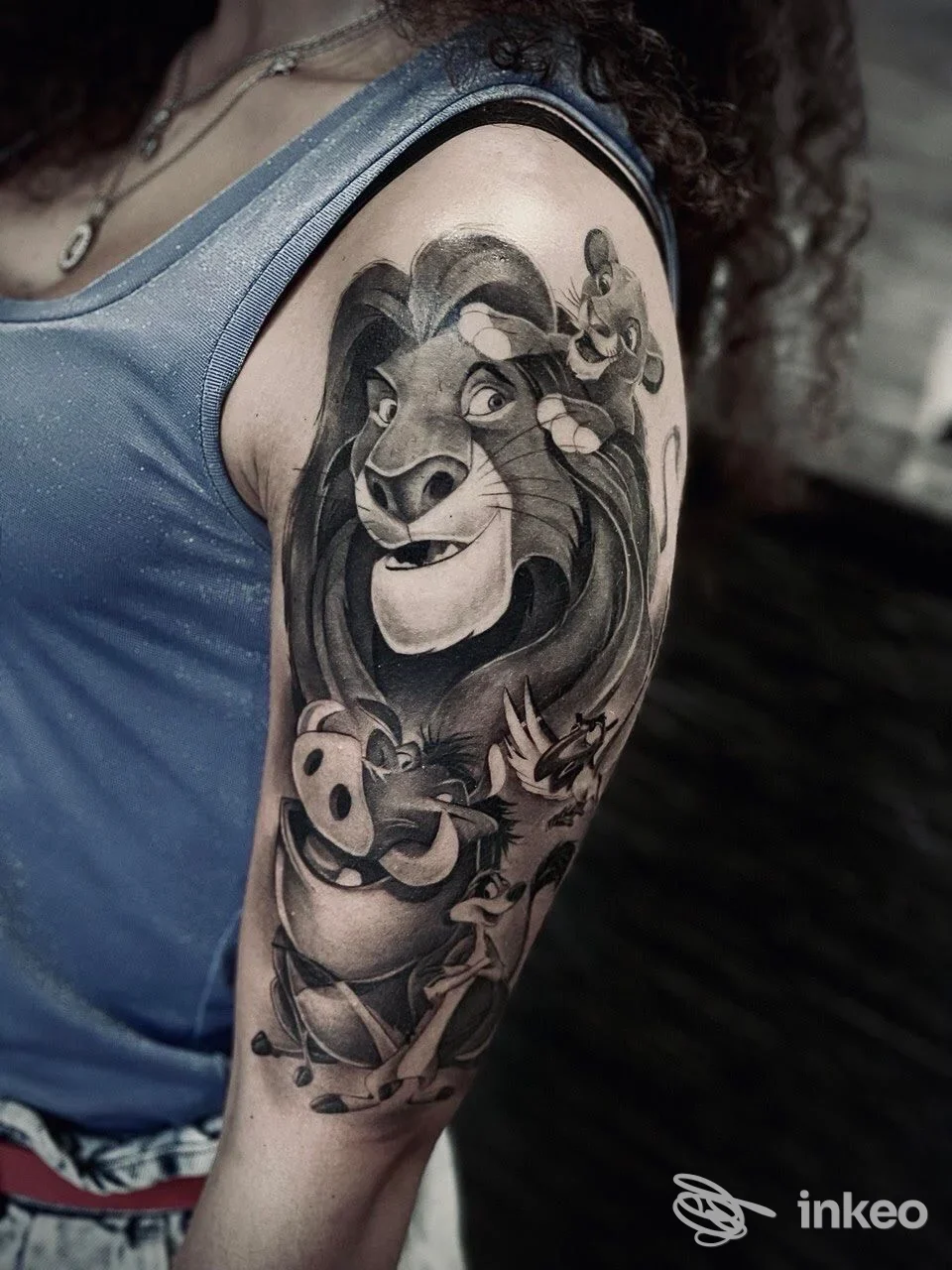 Tatuaggio black and grey su braccio superiore con personaggi stilizzati. Black and Grey Tattoo Shop, Monserrato.