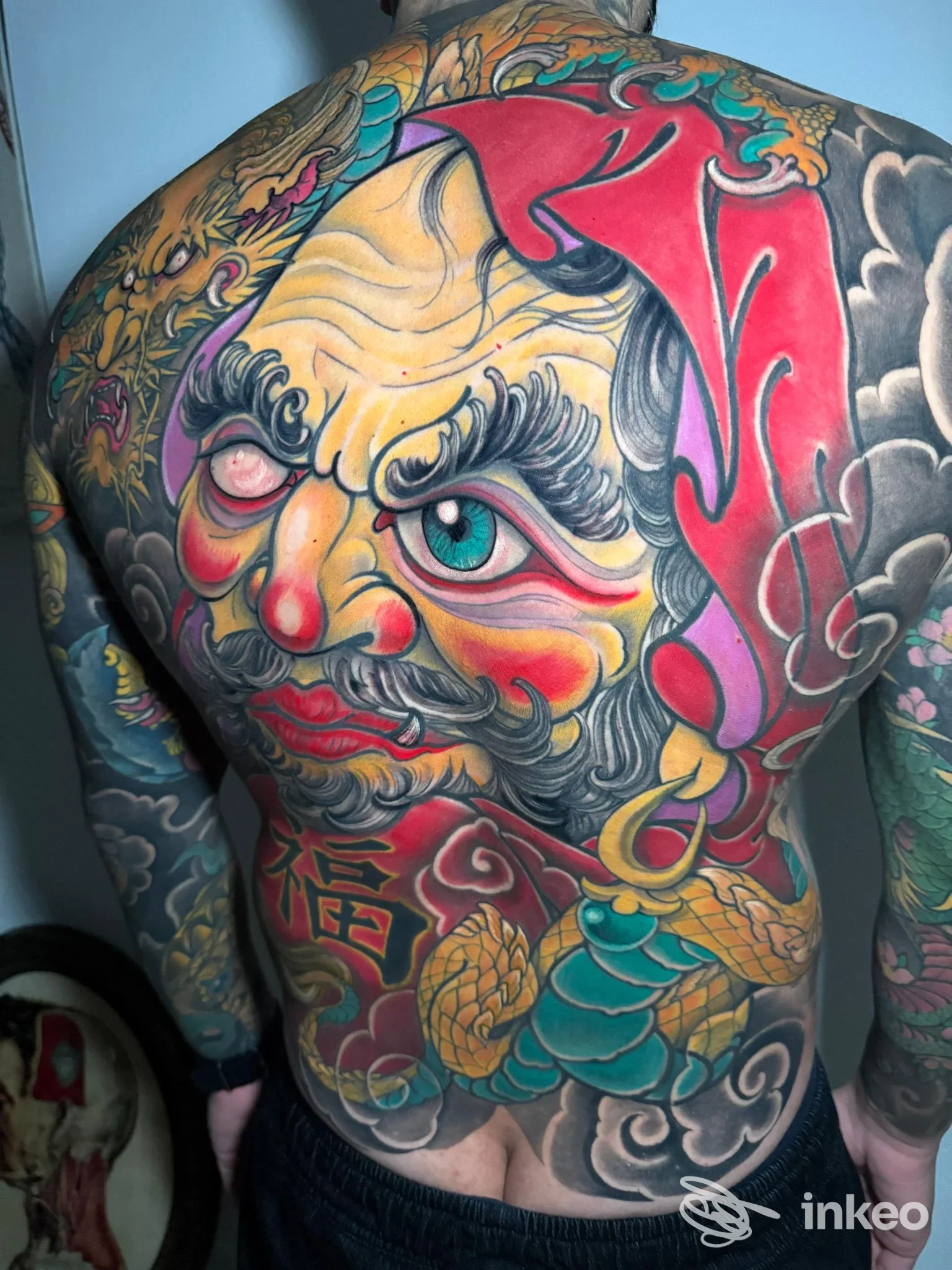 Schiena completamente tatuata con grande composizione figurativa a colori, lavoro di Amon Art Tattoo, Sassari.