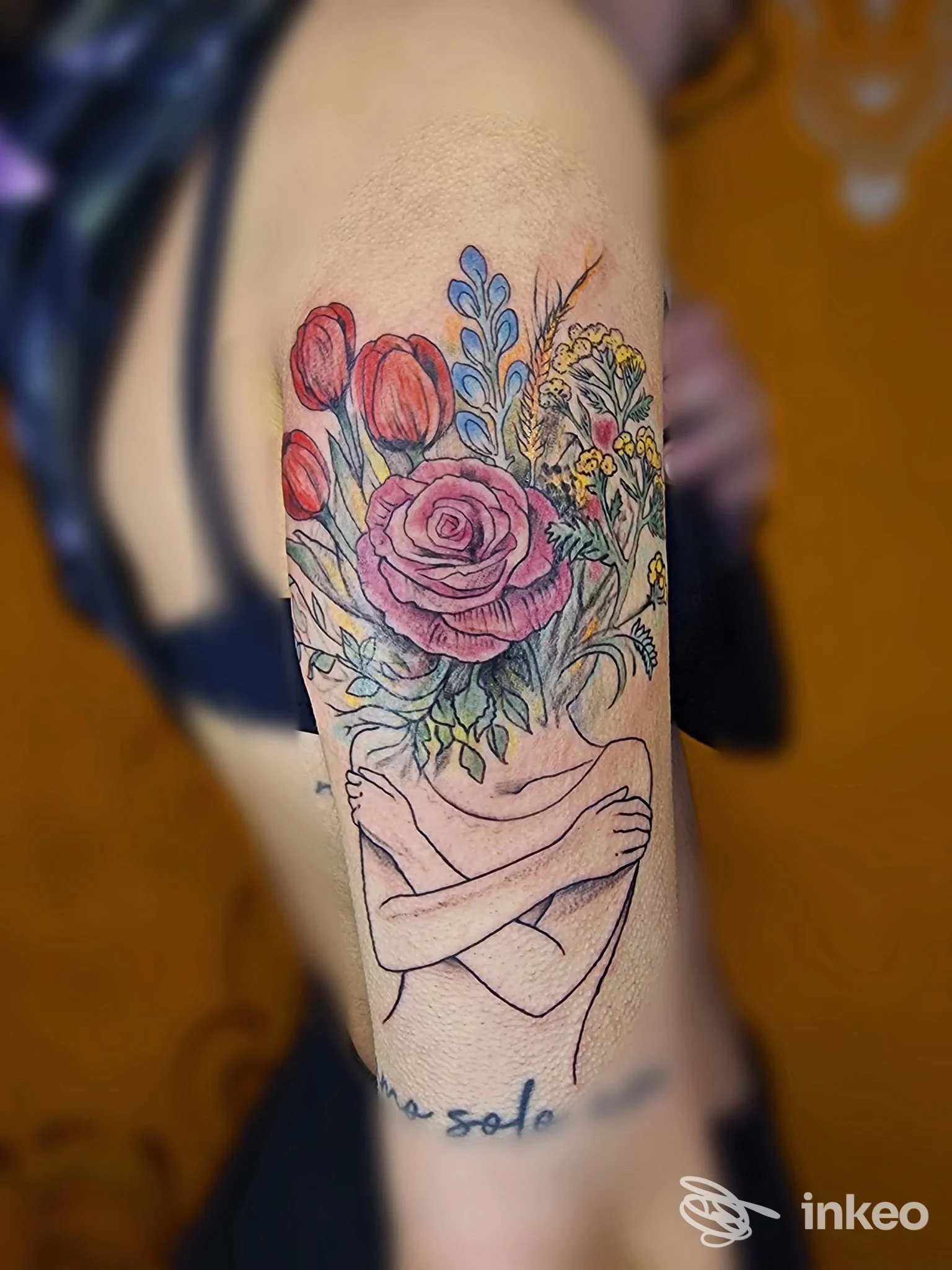 Tatuaggio floreale colorato con rose e fiori su braccio superiore, realizzato da Bizarre Tattoo 777 ad Alghero.