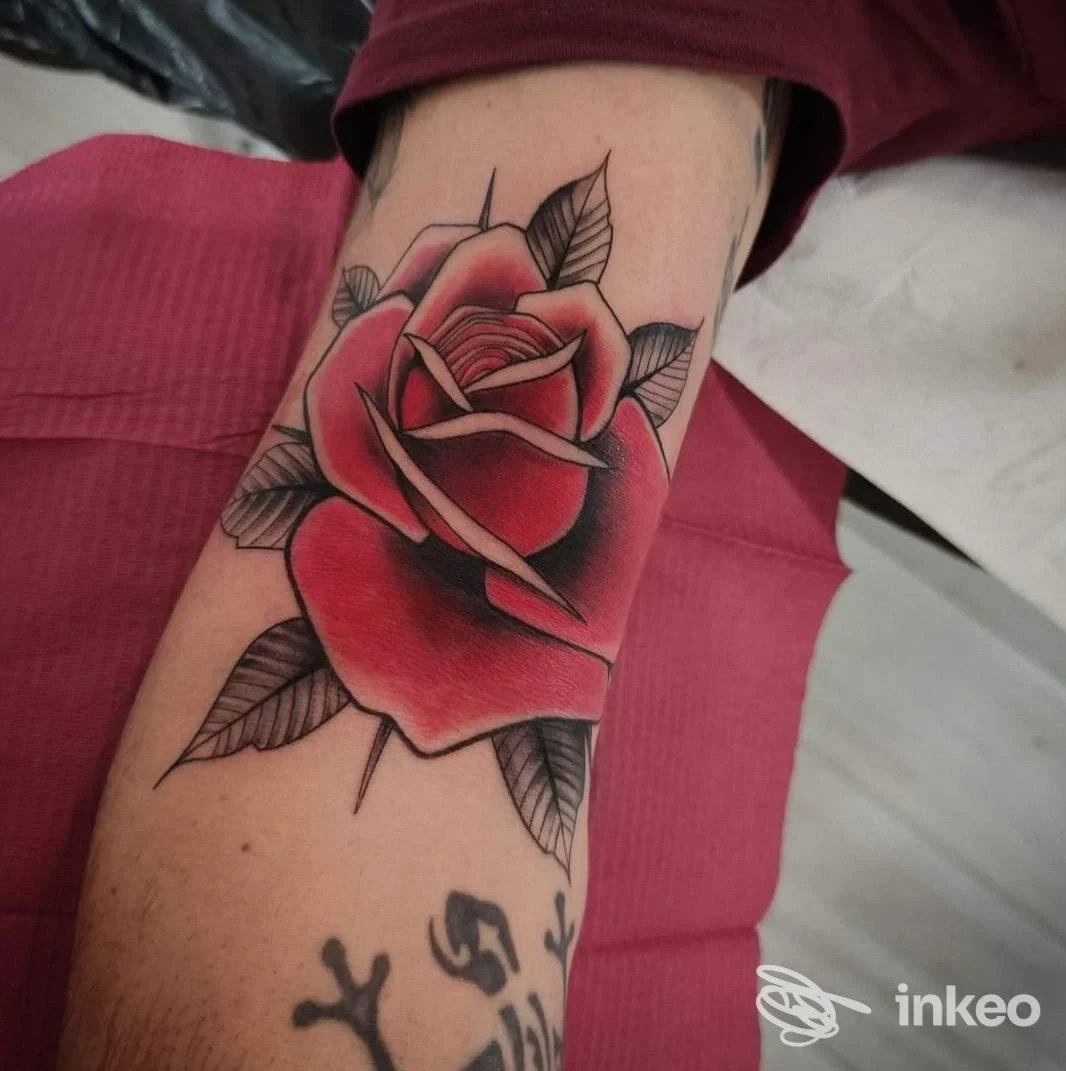 Tatuaggio a rose rosse sull'avambraccio, realizzato da Corazón Espinado Tattoo Shop a Orosei.