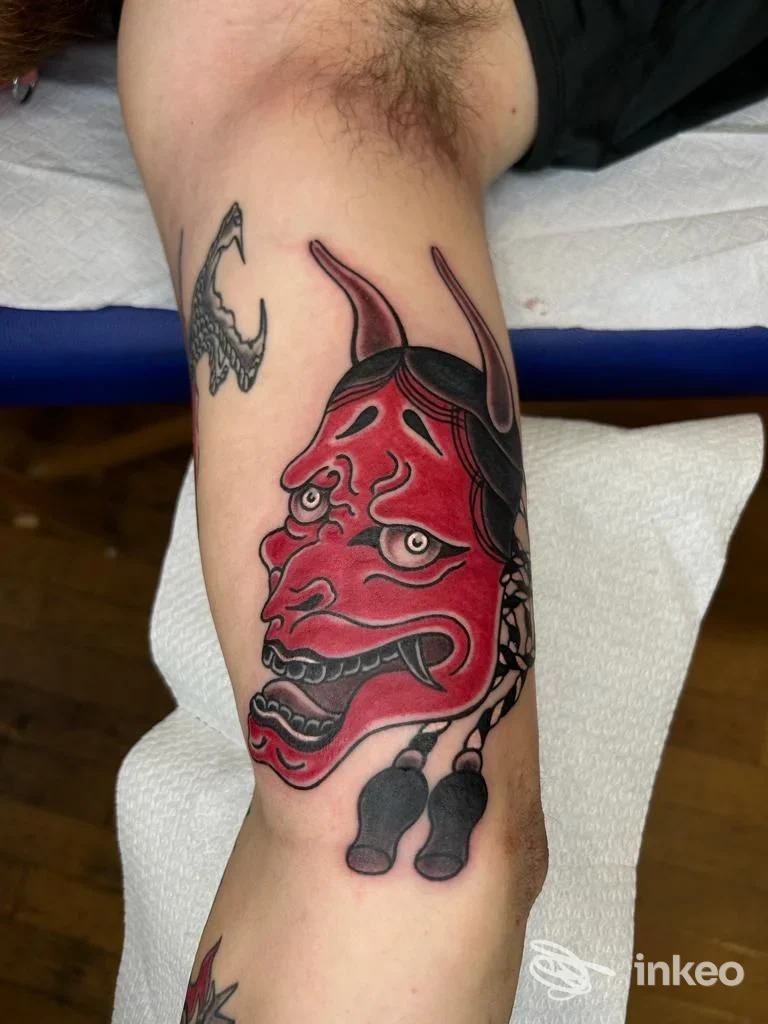 Tatuaggio con maschera demoniaca rossa sull'avambraccio interno. Crazy Cat Tattoo, Cagliari.