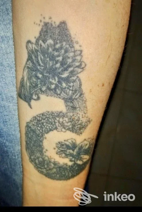 Tatuaggio floreale in nero con dettagli a puntinatura sull'avambraccio, foto fornita da Crazy Cat Tattoo, Cagliari.