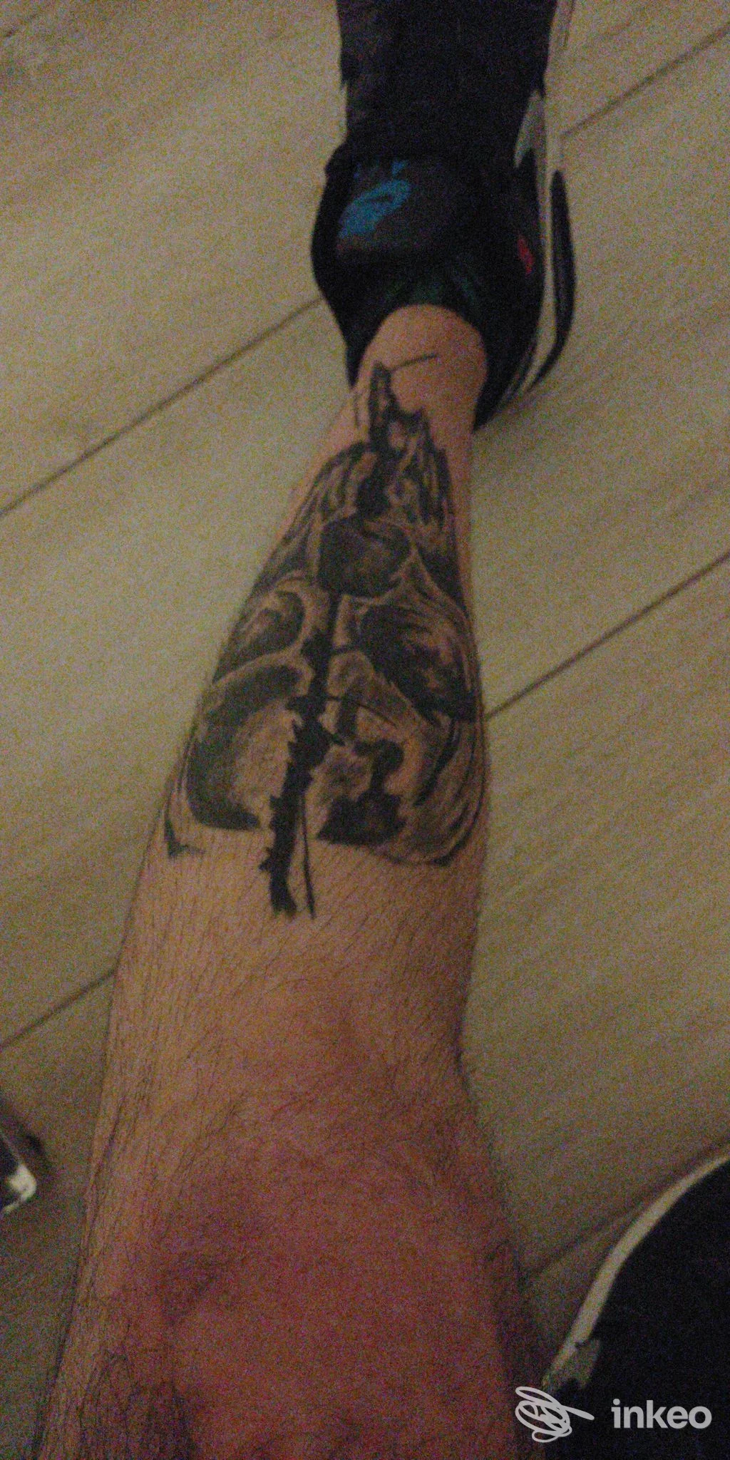 Tatuaggio scuro e coprente sullo stinco, fotografia inviata da Crys Vlad Tattoo, Sassari.