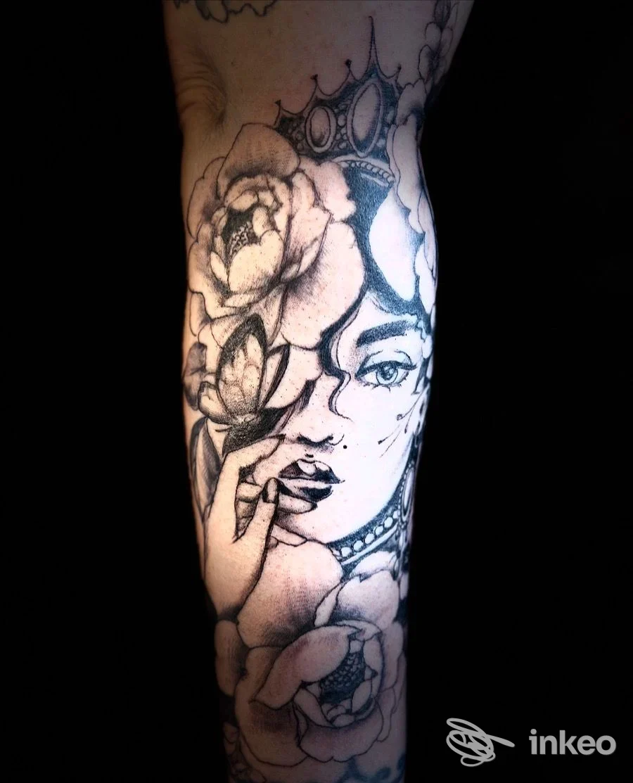 Tattoo sull'avambraccio raffigurante una donna con corona e grandi fiori, disegno in stile linework.