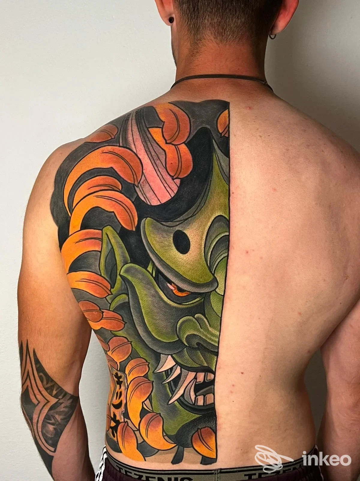 Grande tatuaggio colorato che copre la metà sinistra della schiena, foto fornita da Cagliari Classic Tattoo, Cagliari.