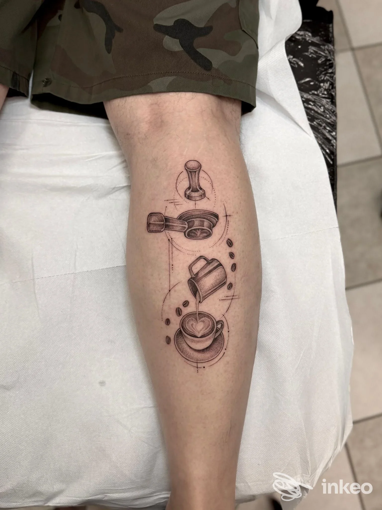 Tatuaggio linework a tema caffè sul polpaccio, foto inviata da Free Mind Tattoo a Quartu Sant'Elena, dettaglio in bianco e nero.