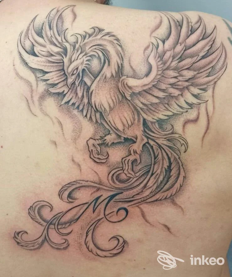Grande tatuaggio di fenice sul dorso realizzato da GD Tattoo a Terralba, con linee marcate, ombreggiature puntinate e dettagli decorativi.
