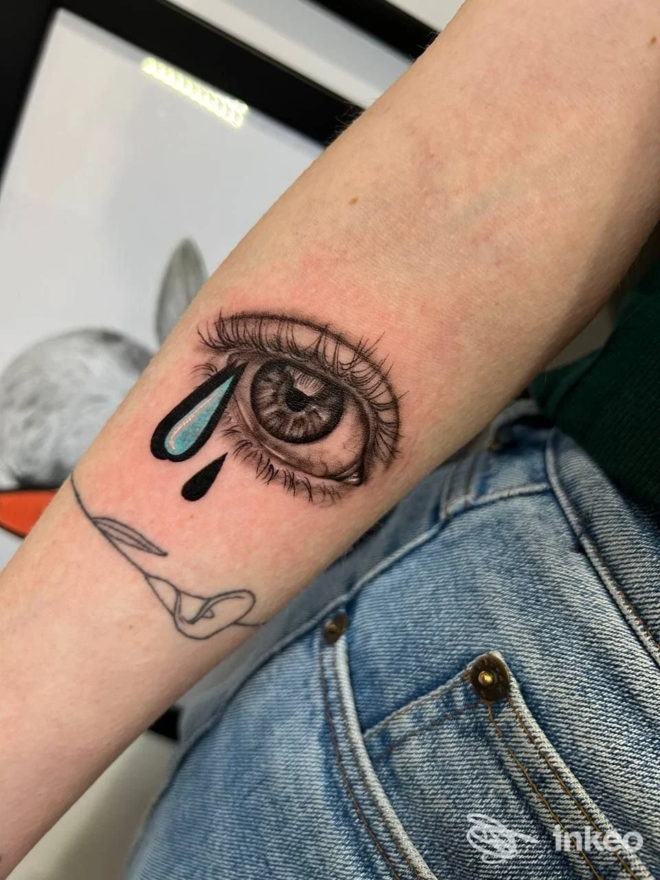 Tatuaggio a forma di occhio con gocce blu sull'avambraccio, fotografia inviata da Giorgia Soro Tattoo Sardegna, La Caletta.