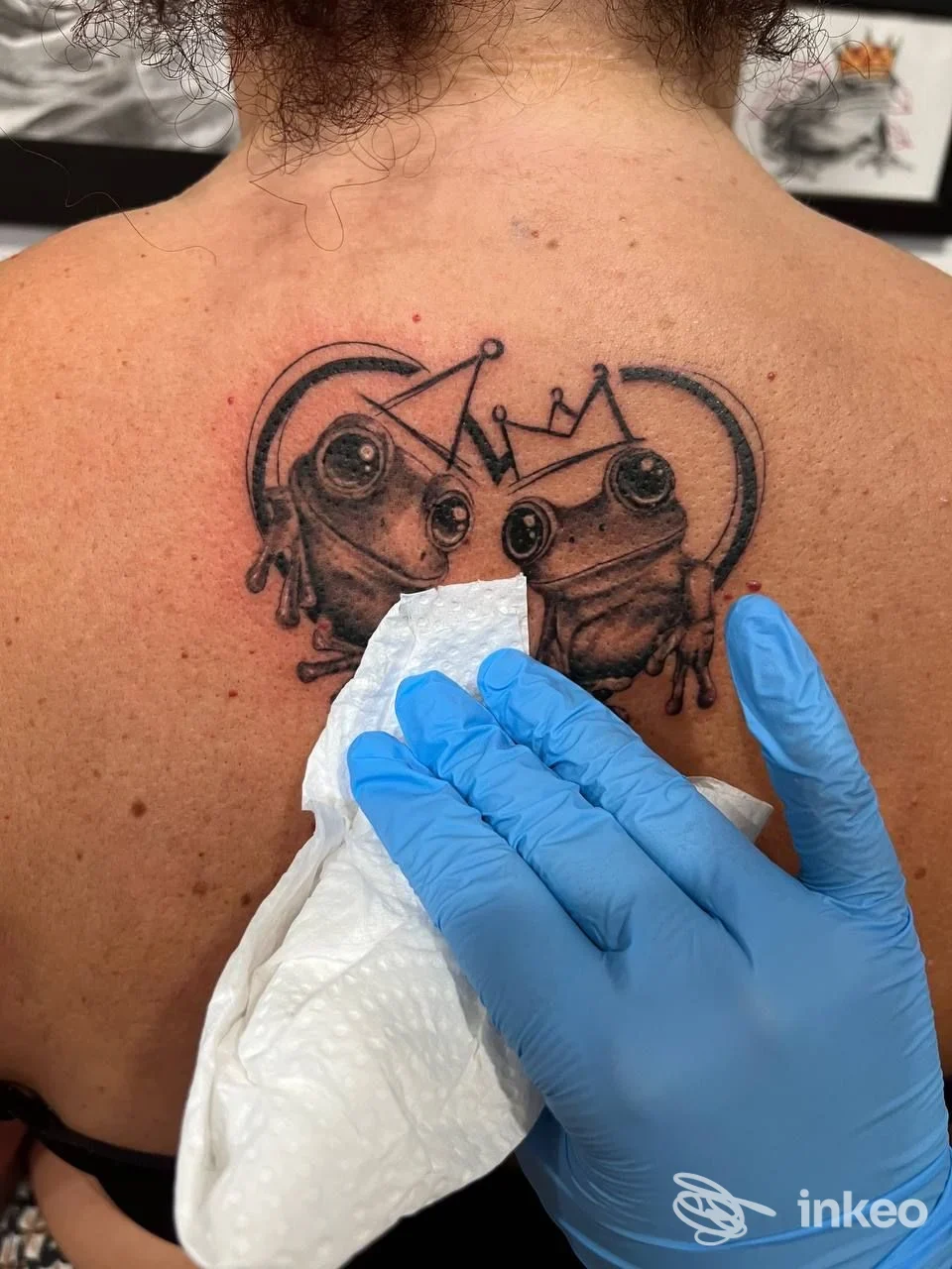 Tatuaggio di due rane coronate sulla parte superiore della schiena; immagine dal studio Giorgia Soro Tattoo Sardegna, La Caletta.