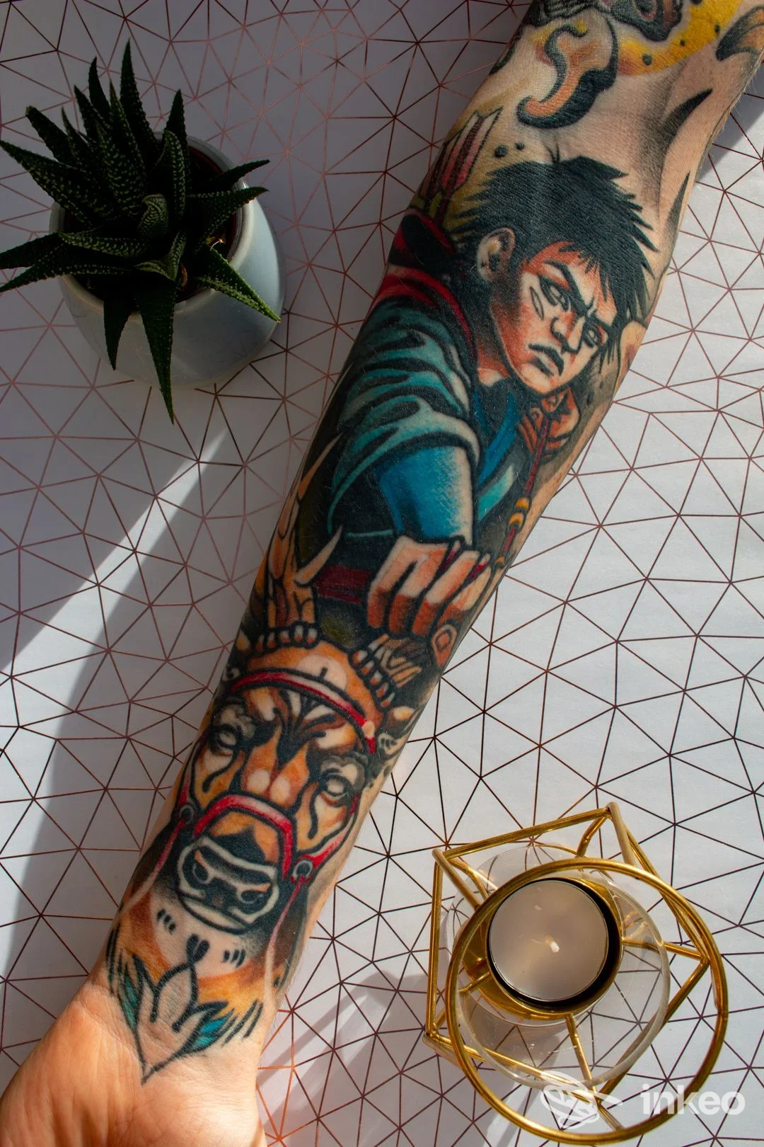 Tatuaggio a colori su avambraccio con personaggio illustrativo e testa di animale, foto fornita da Ink Lab Tattoo Studio, Oristano.