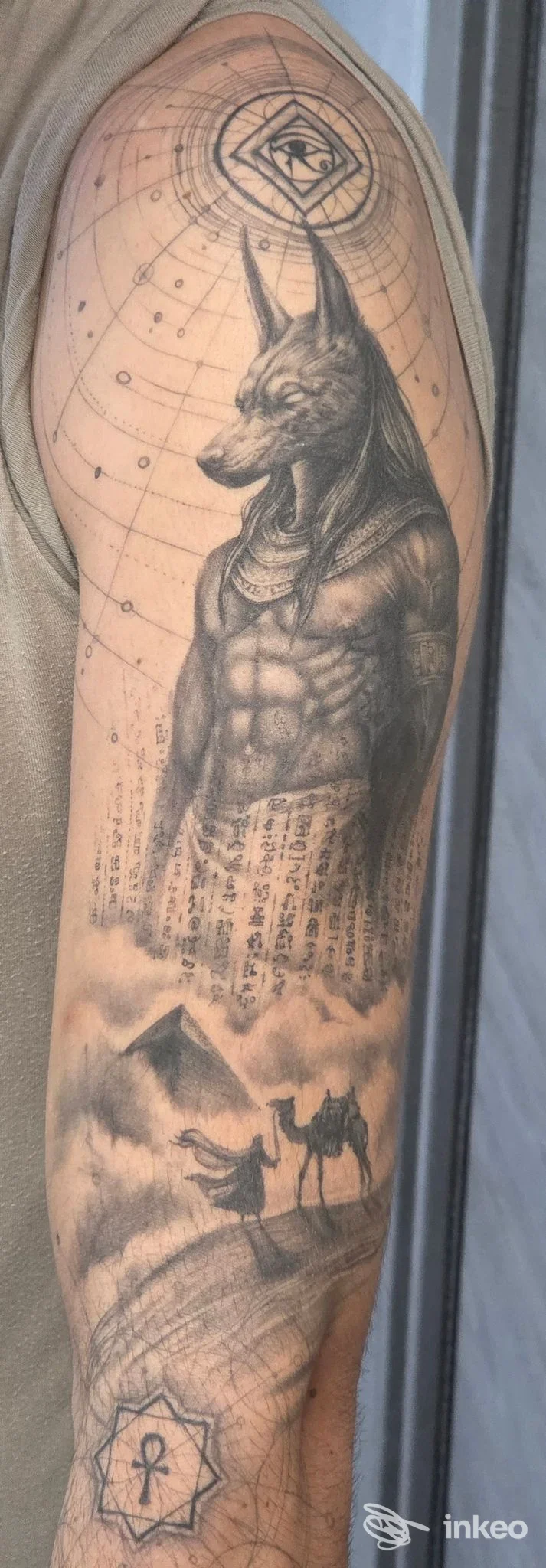 Tatuaggio a manica con figura antropomorfa Anubi, paesaggio e geometrie; immagine fornita da Konfido Tattoo Studio, Oristano.