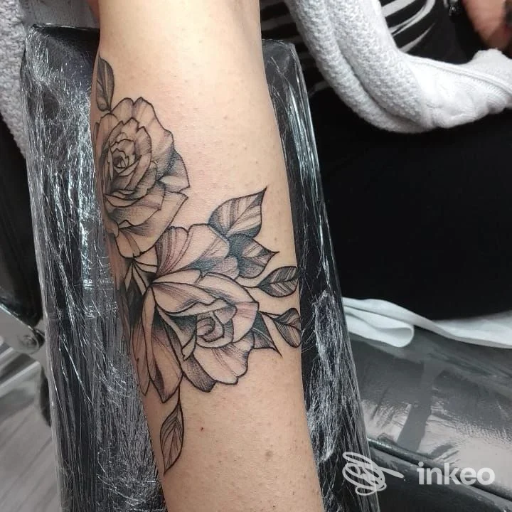 Primo piano dell'avambraccio con tatuaggio di rose in bianco e nero, realizzato presso Liner And Shader Tattoo Studio a Quartu Sant'Elena.