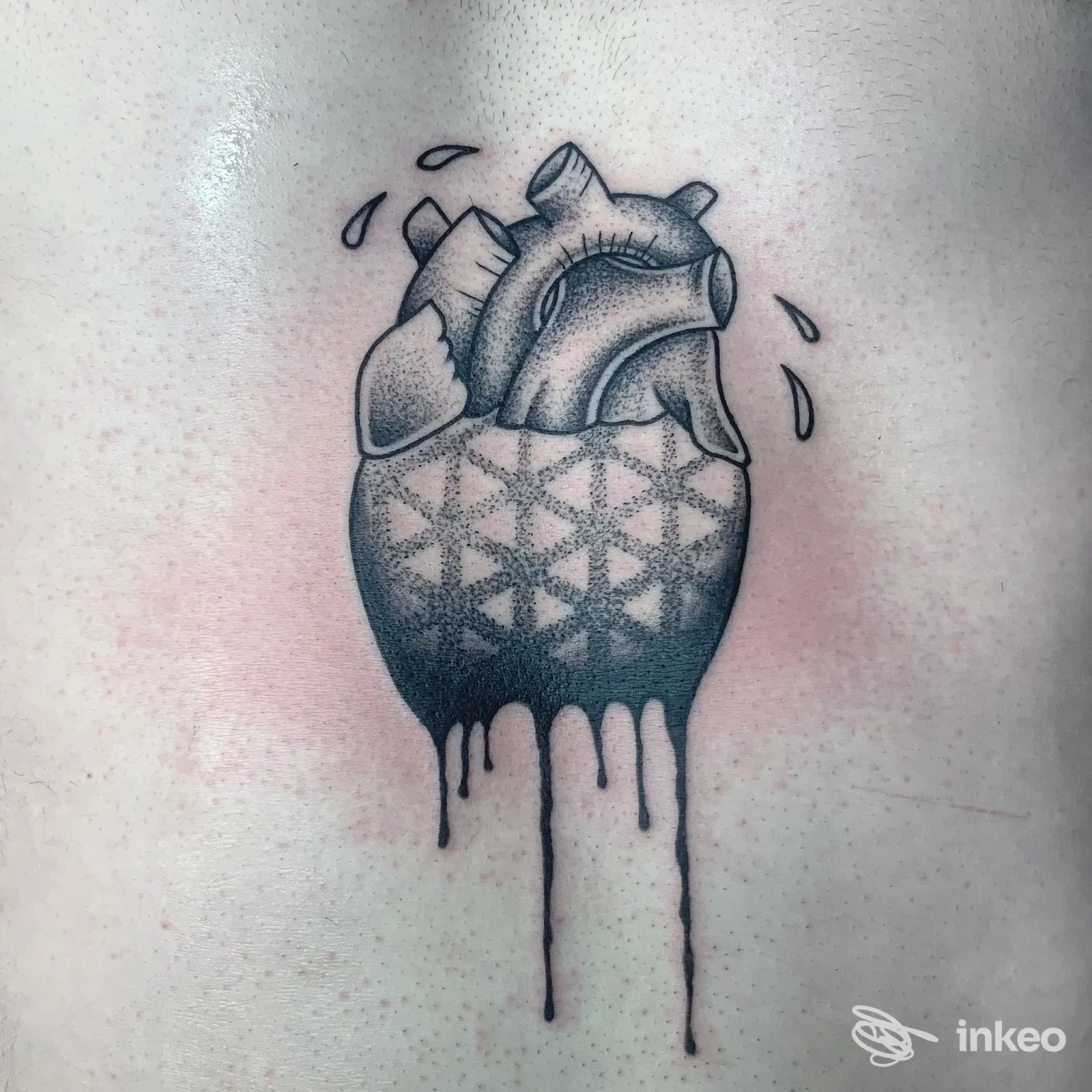Tatuaggio a cuore anatomico con motivi geometrici e dripping, realizzato da Mad Ink Tattoo a Simaxis sul torace.