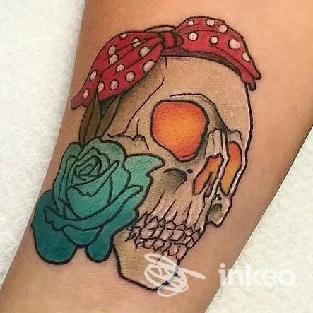 Tatuaggio su avambraccio di un teschio colorato con fiocco e rosa, lavoro di Minimal Ink Tattoo Studio a Dolianova.