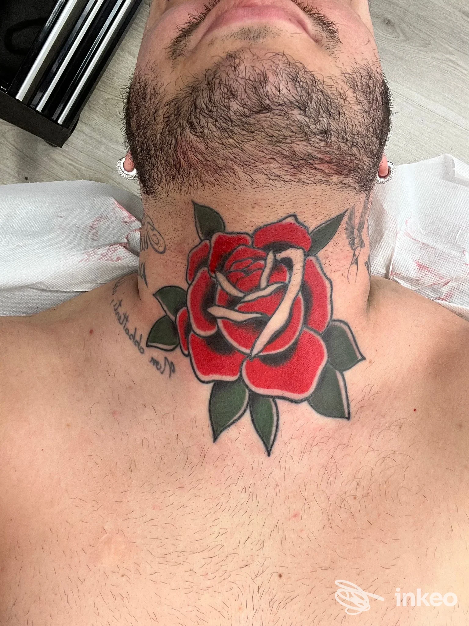 Primo piano di un tatuaggio a rosa rossa sul collo realizzato da NUMB Tattoo Parlour, Porto Torres.