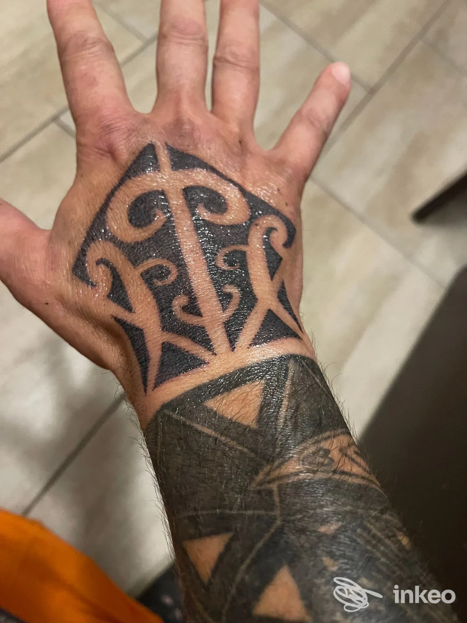 Tatuaggio nero ornamentale su dorso della mano e avambraccio, foto per Rebis Tattoo di Sara Pushi a Sassari.