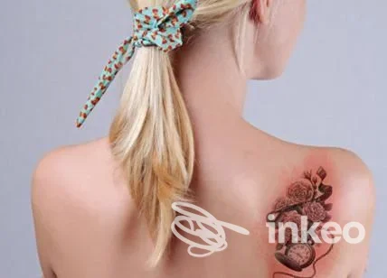 Donna di schiena con tatuaggio floreale sulla spalla destra, immagine per Red Skin Tattoo, Nuoro.