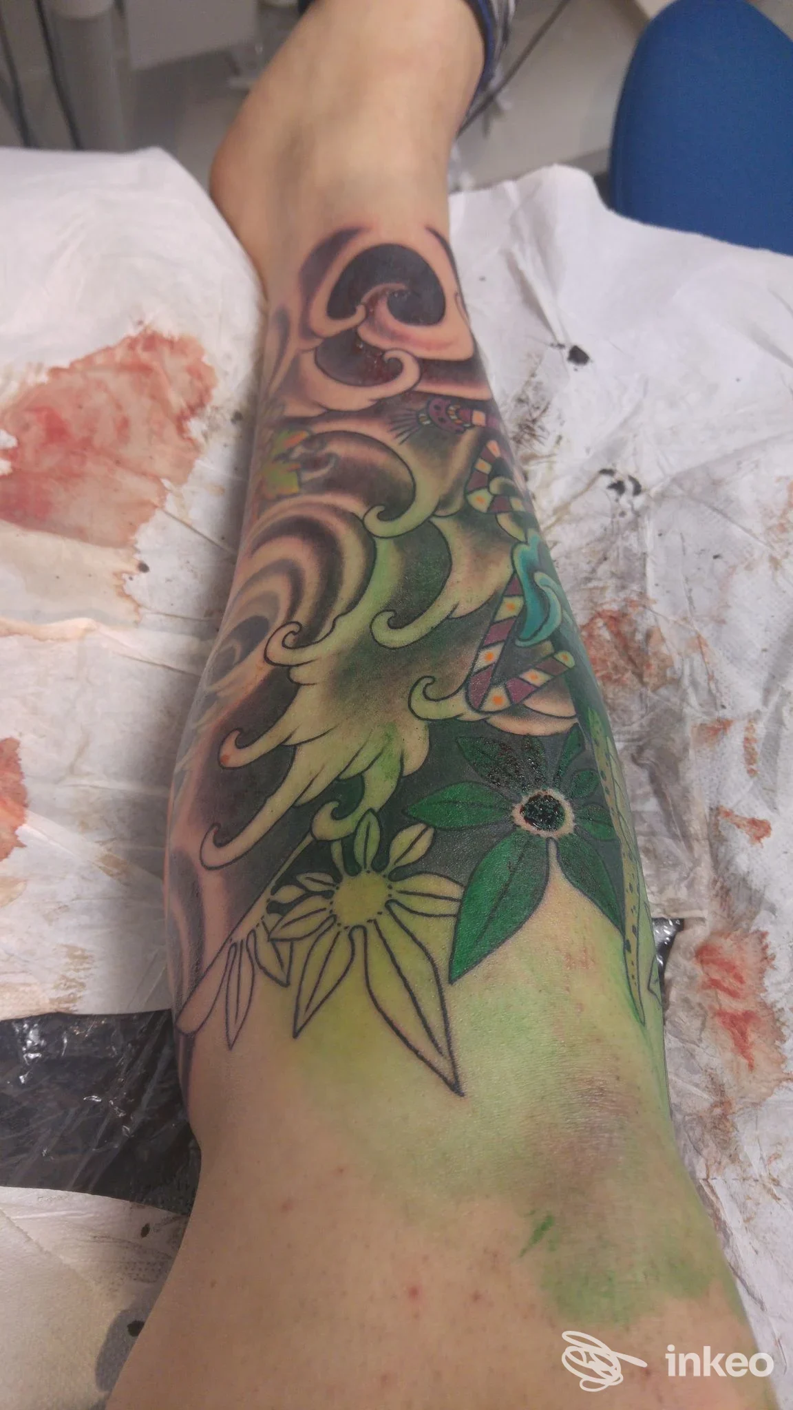 Tatuaggio a colori sul polpaccio con motivi floreali e onde, foto dallo studio Red Skin Tattoo, Nuoro.