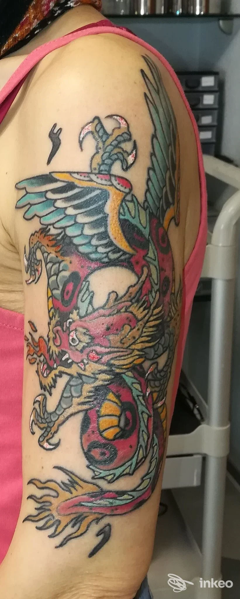 Grande tatuaggio a colori di un drago sulla spalla e braccio superiore, Red Skin Tattoo, Nuoro.