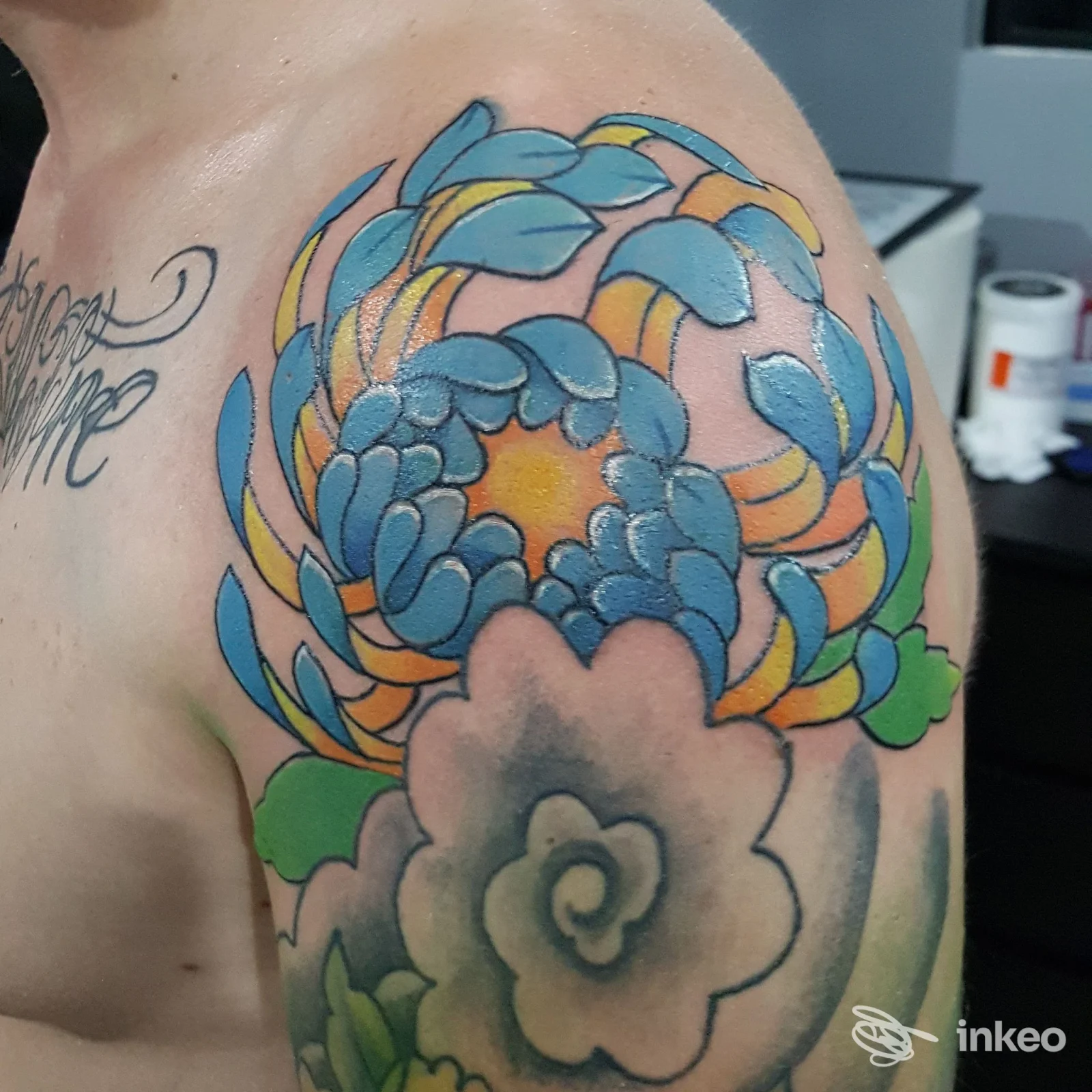 Tatuaggio floreale colorato sulla spalla e parte superiore del braccio, fotografia fornita da 34 Studio Tattoo di Palermo.