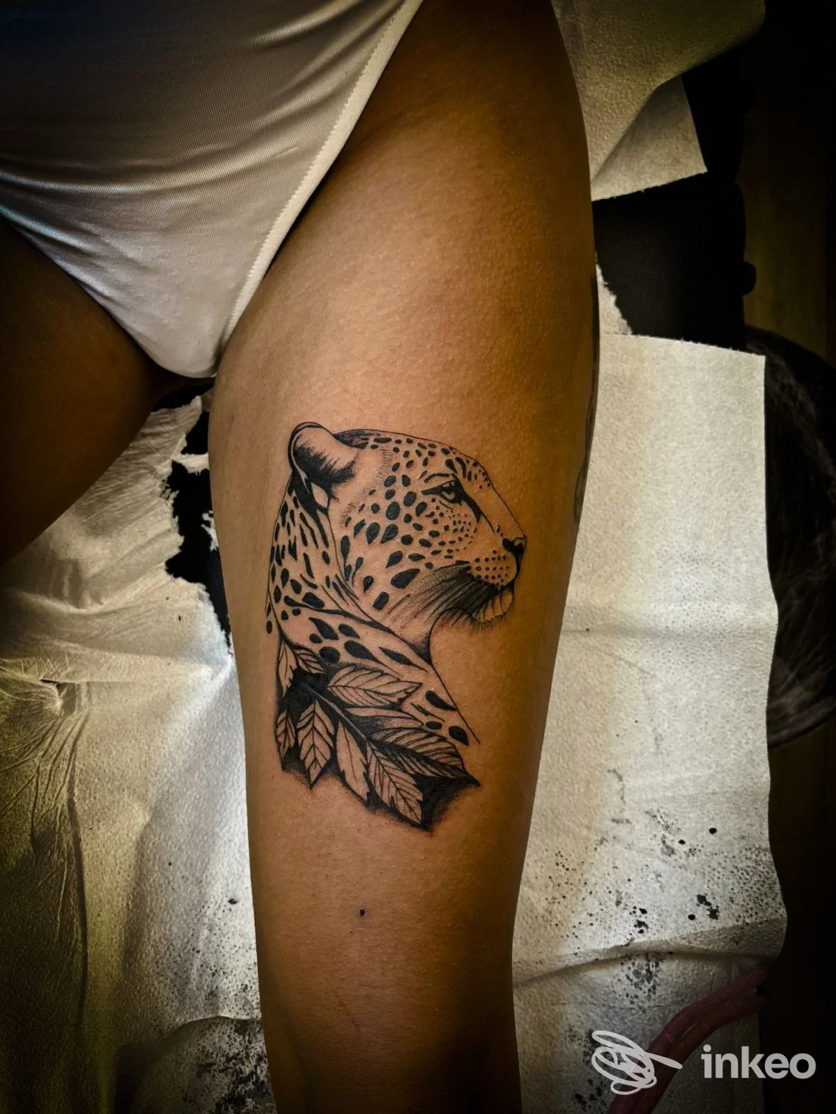 Tatuaggio testa di leopardo con foglie sulla coscia, ART GALLERY.INK TATTOO, Sambuca di Sicilia.