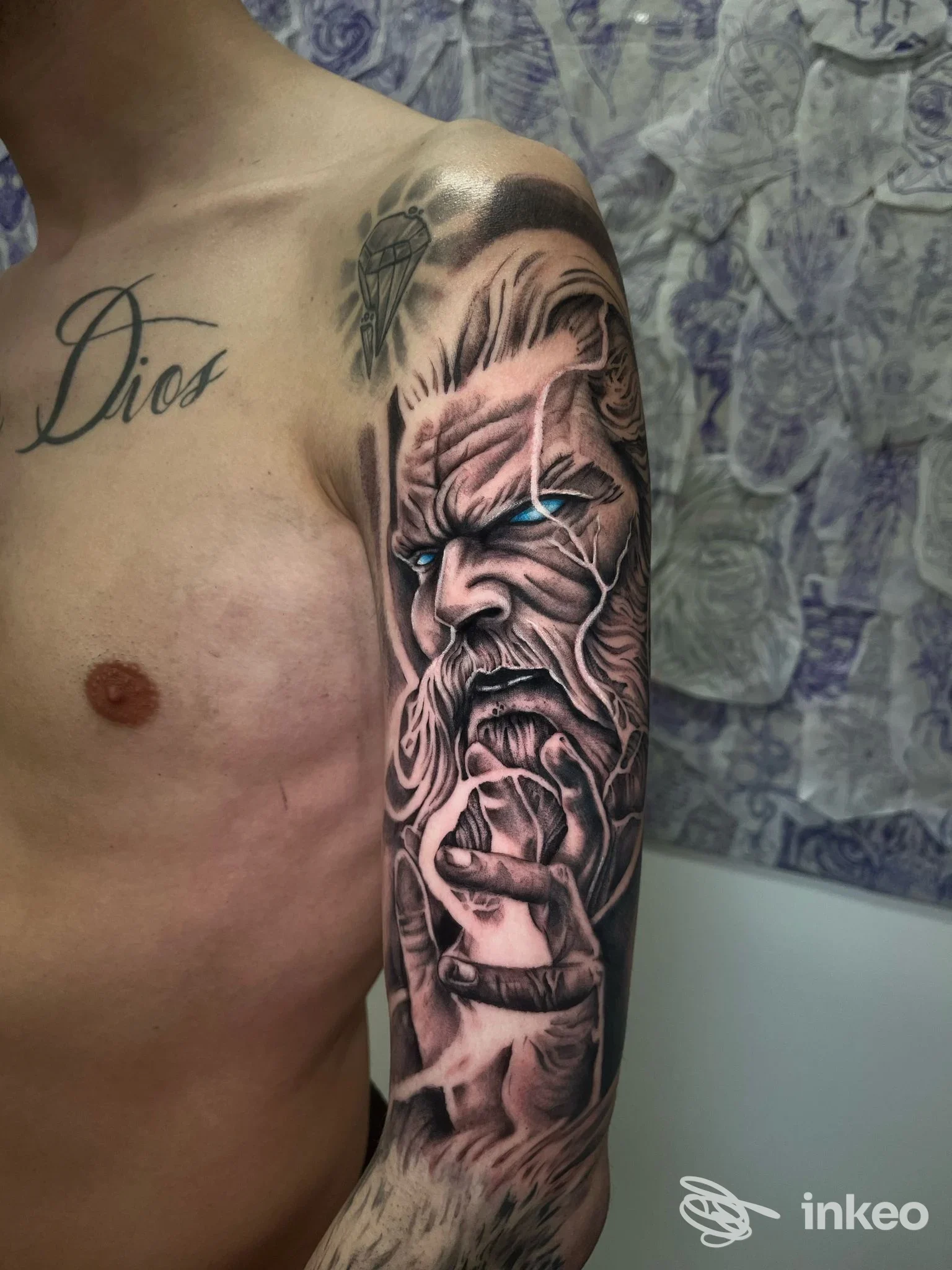Mezza manica realistico in bianco e nero su braccio e spalla, ritratto con occhi blu, Alma Romantica tattoo studio, Brolo.