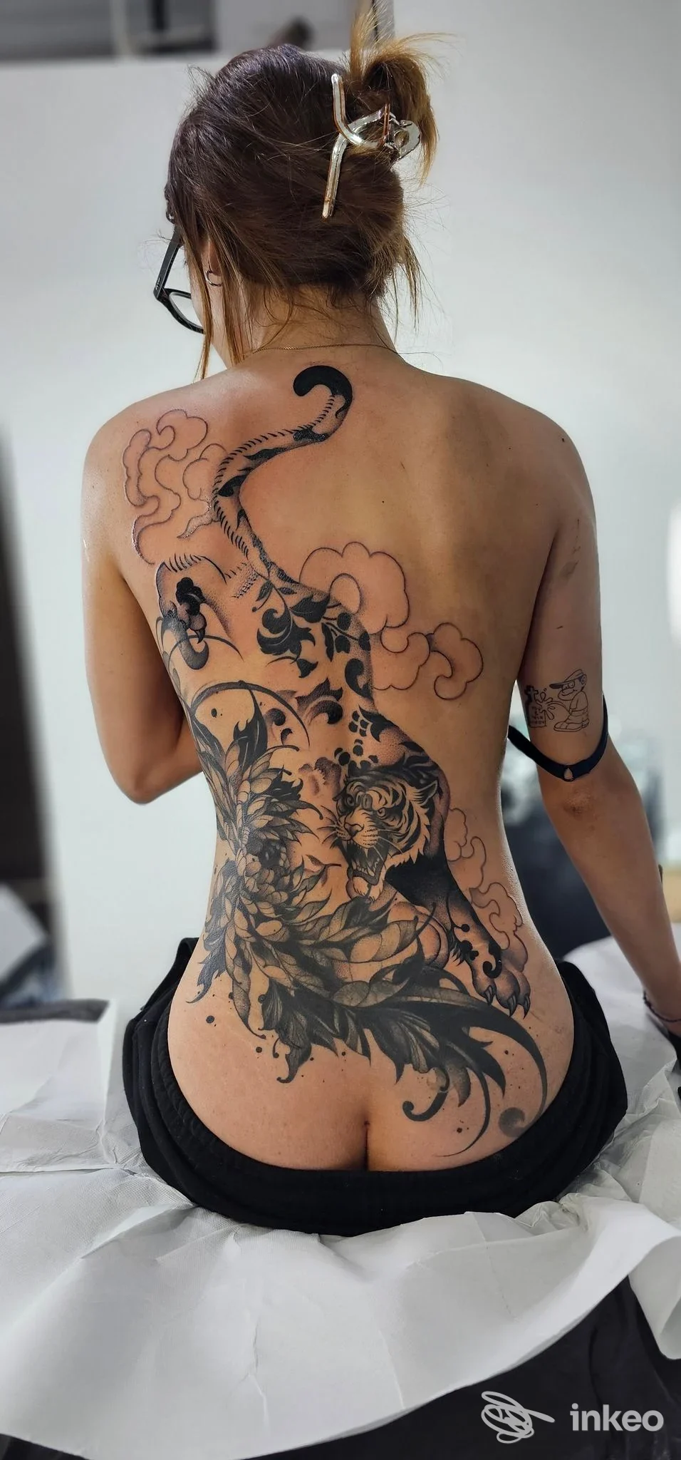 Donna di schiena con ampio tatuaggio blackwork floreale che copre gran parte della schiena, foto da Anna Caminiti Tattoo a Messina.