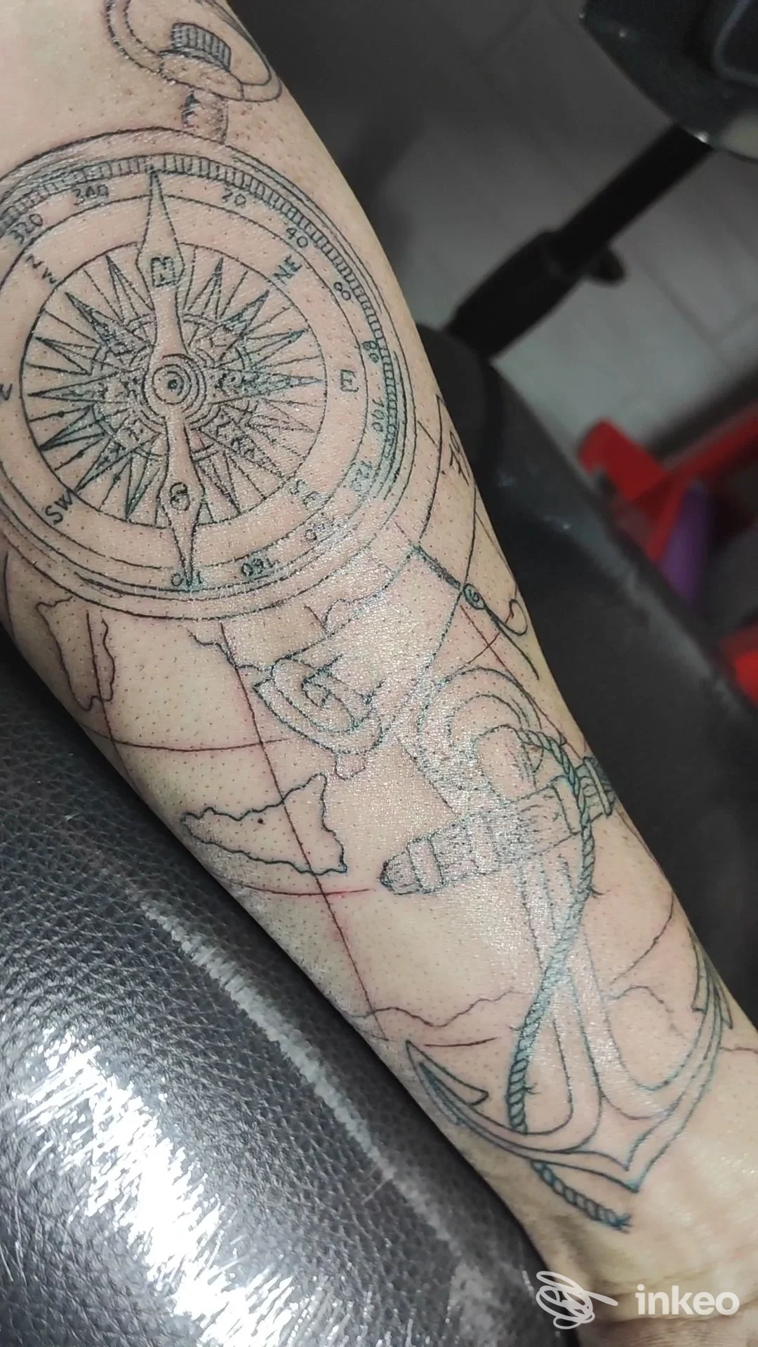 Tatuaggio su avambraccio con bussola e ancora in linework nero, foto scattata nello studio Alfyink Tattoo a Palermo.