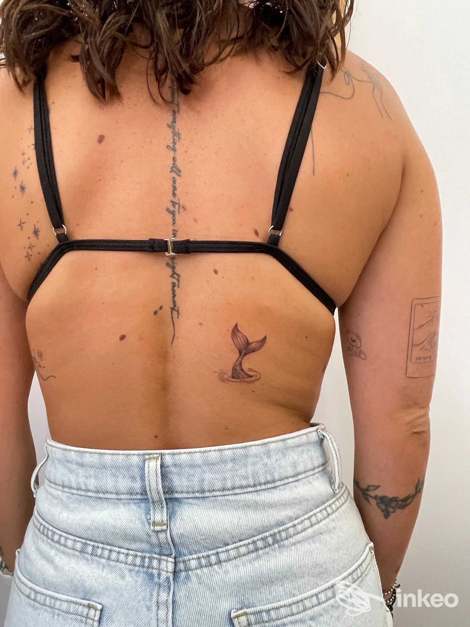 Schiena di una persona con diversi tatuaggi, in primo piano una coda di sirena; immagine fornita per Art Box Tattoo, Alcamo.