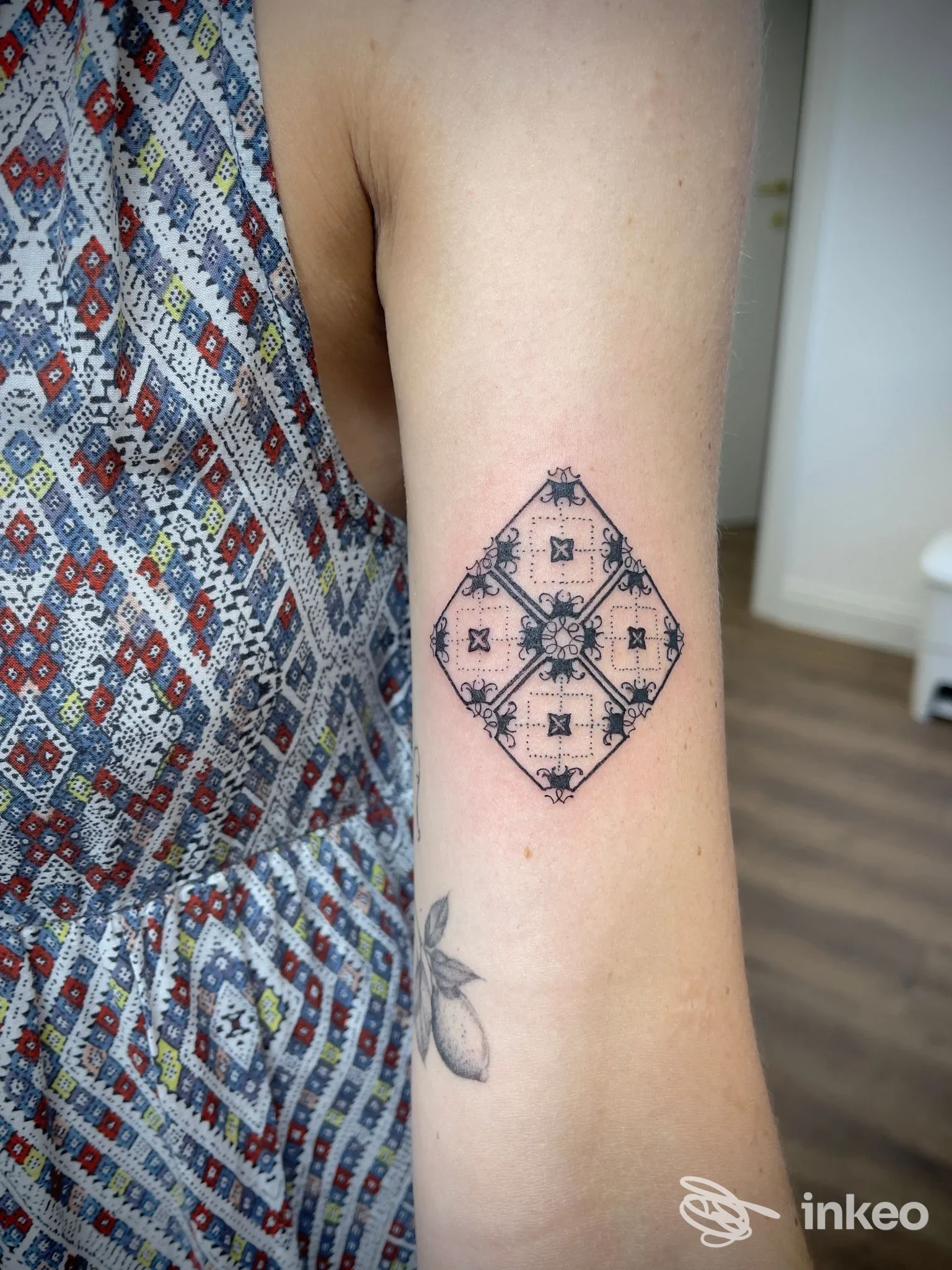 Tatuaggio geometrico nero a rombo sul bicipite interno, scatto in studio Art Box Tattoo ad Alcamo.