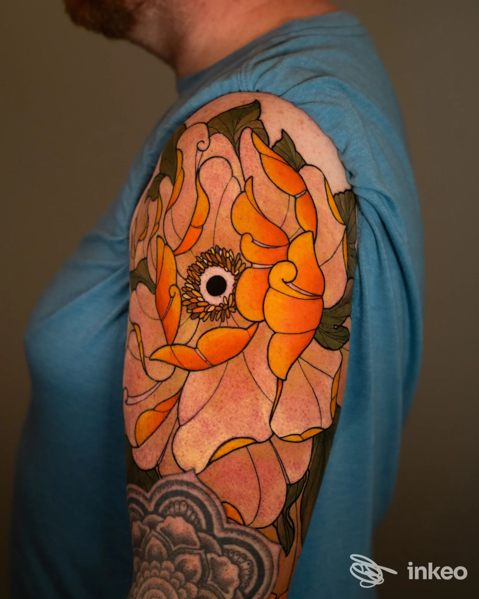 Grande tatuaggio floreale colorato sul braccio superiore, fotografia eseguita da Bānum Tattoo Studio a Palermo.
