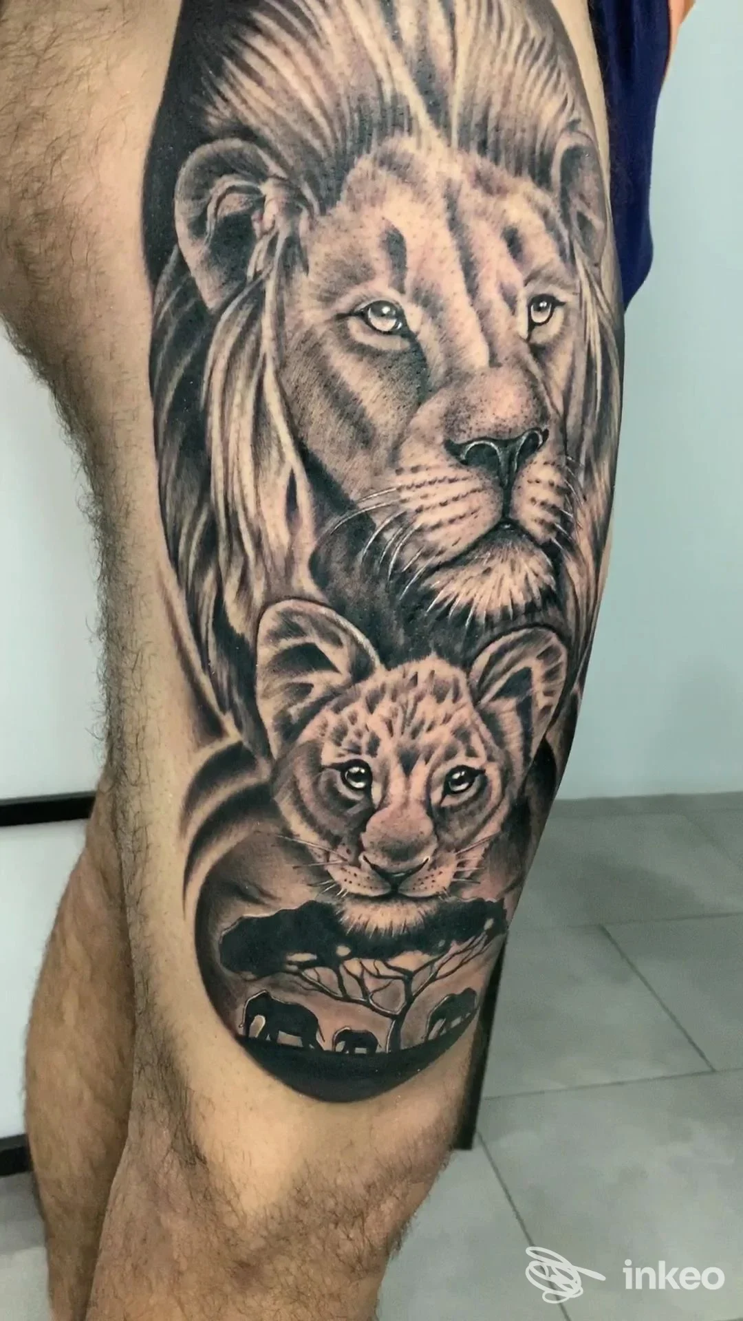 Tatuaggio realistico in bianco e nero di un leone e un cucciolo sulla coscia, Black Stones Ink tattoo studio, Santa Teresa di Riva.