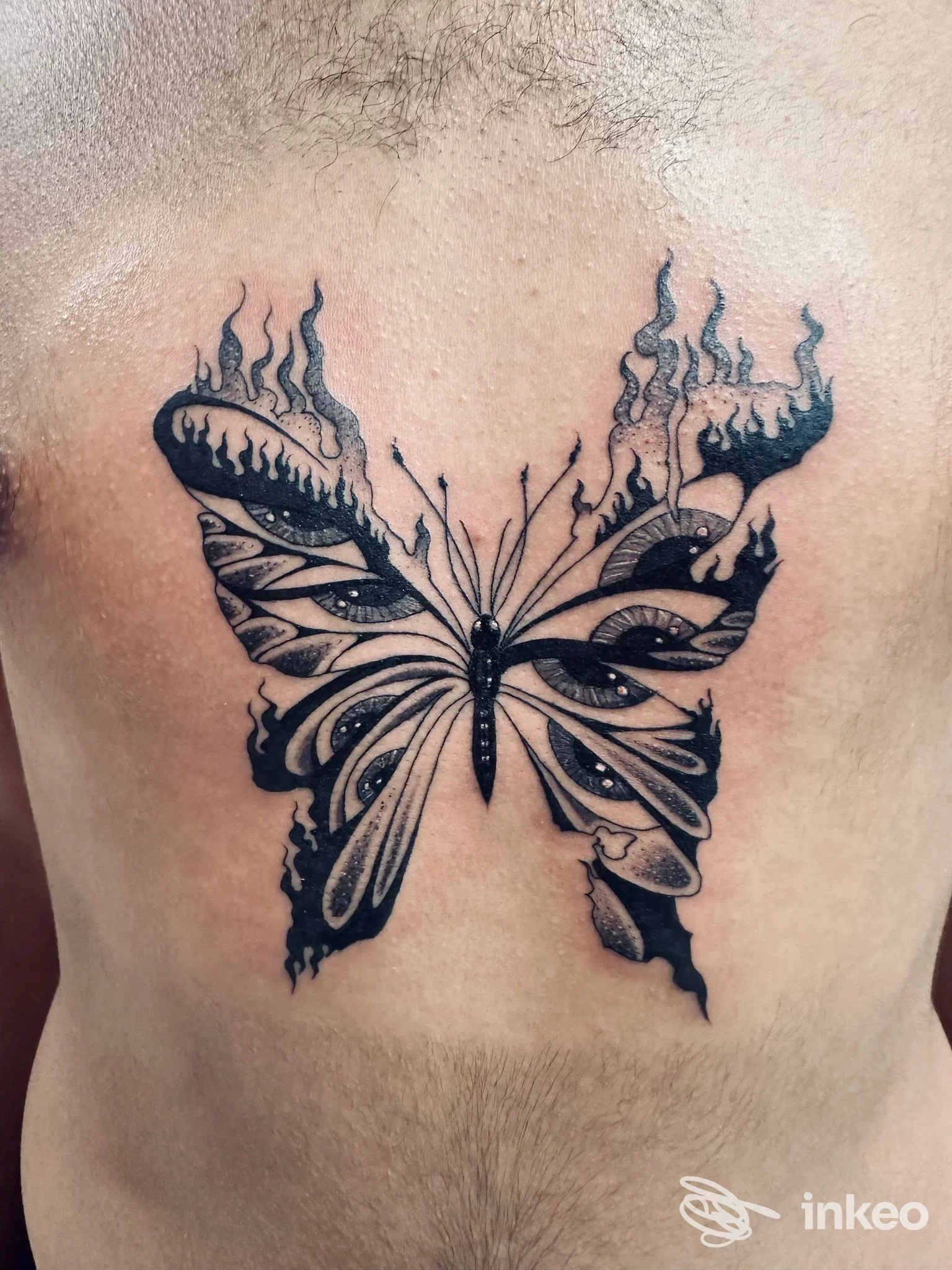 Tatuaggio a farfalla in nero sul petto di un cliente, fotografia del lavoro realizzato al Black Milk Tattoo Studio a Messina.
