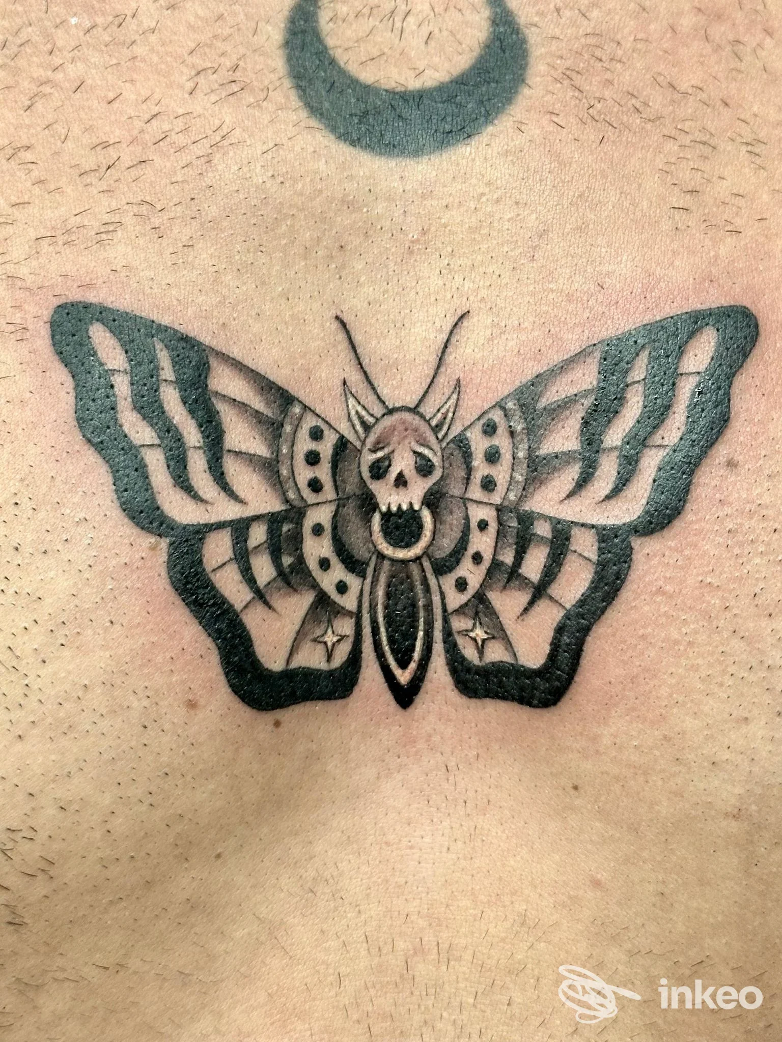 Tatuaggio farfalla/manduca con teschio al centro sul petto, realizzato da Black Milk Tattoo Studio a Messina.