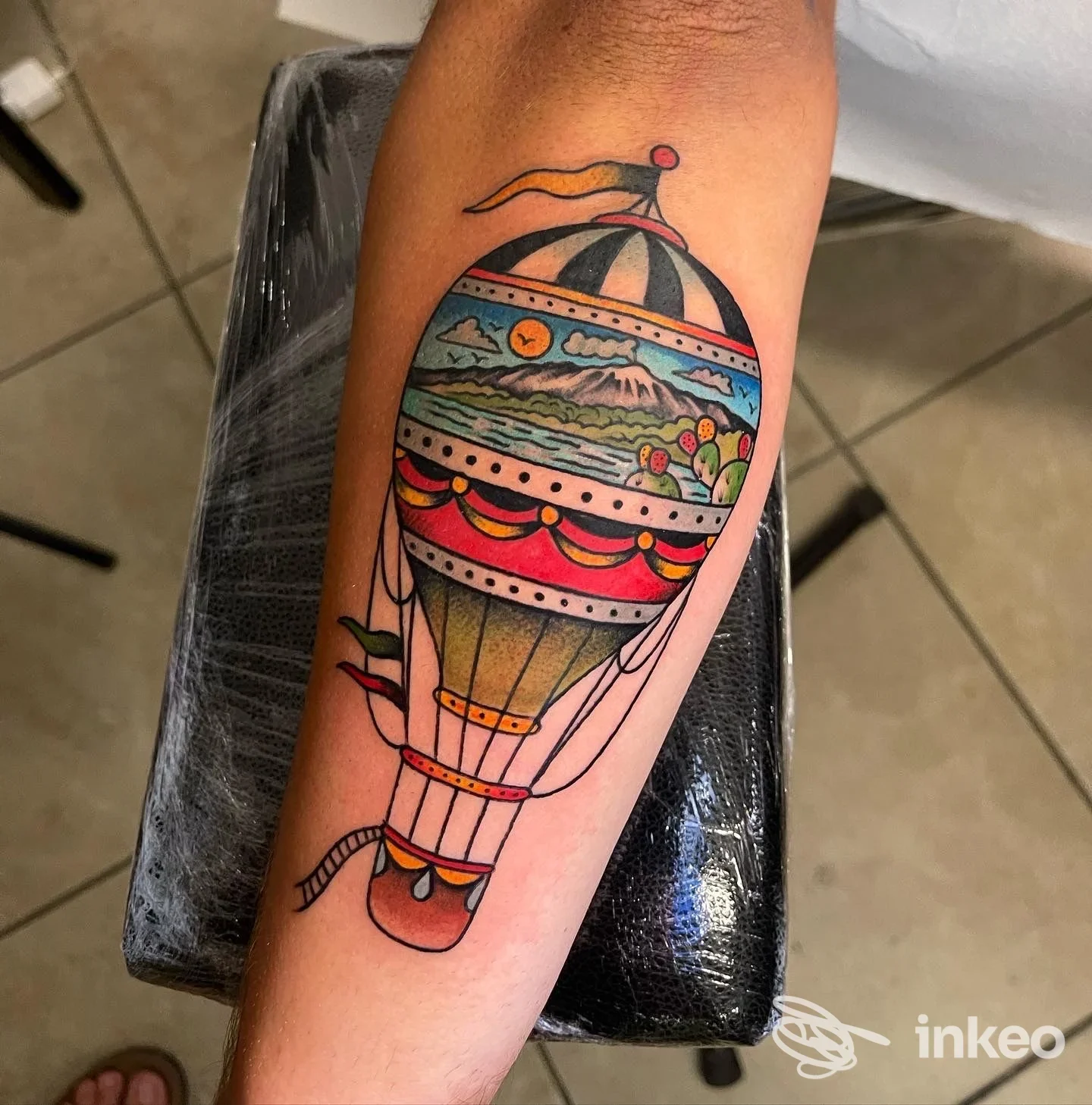 Tatuaggio a colori di una mongolfiera sull'avambraccio, foto dallo studio Black Soul Tattoo a Giardini-Naxos.
