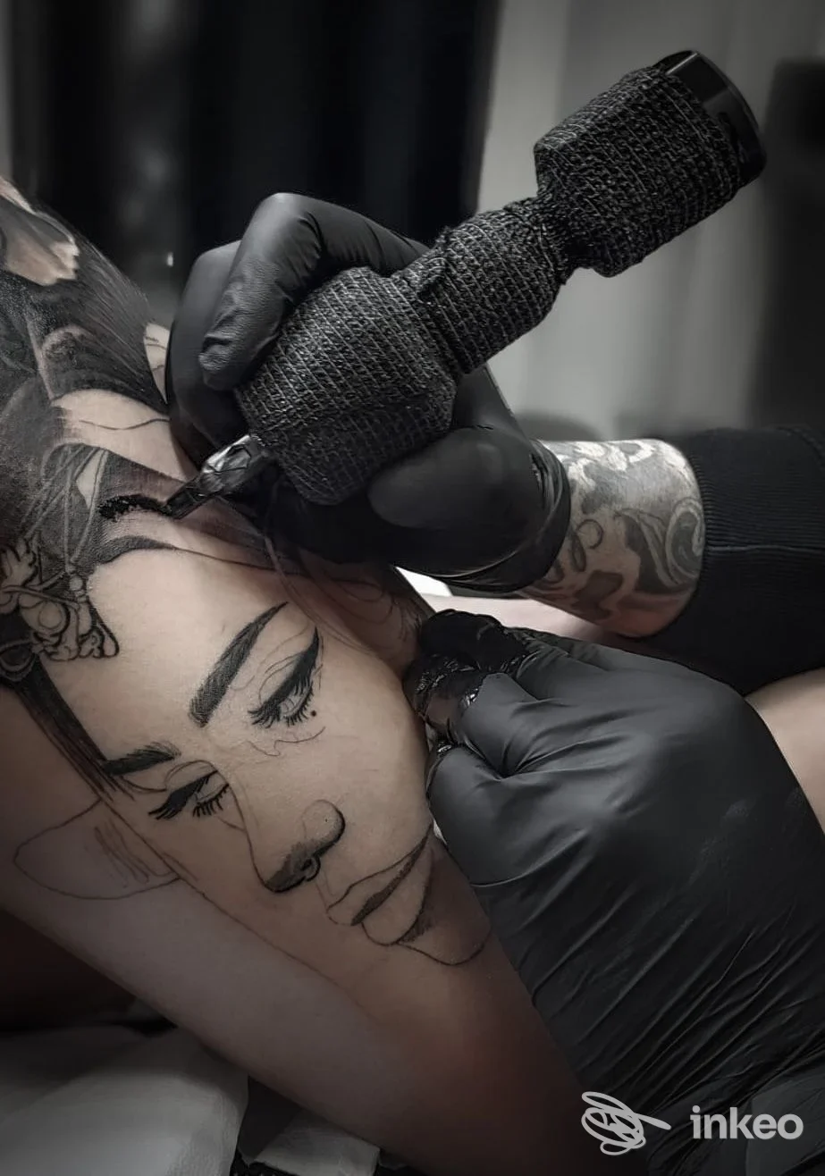 Tatuaggio ritratto in corso su coscia, artista al lavoro allo studio Cash Only Tattoo di Izzi Vincenzo a Torregrotta.