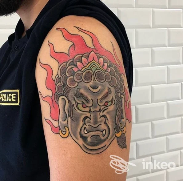 Tatuaggio a colori su bicipite con testa stilizzata e fiamme, foto fornita da Dark Side Palermo, Palermo.