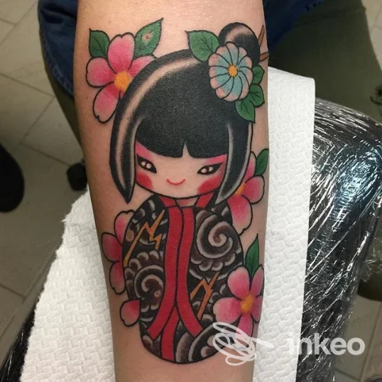 Tatuaggio colorato a Palermo presso Dark Side Palermo - Private Tattoo Studio: bambola kokeshi con fiori sull'avambraccio.