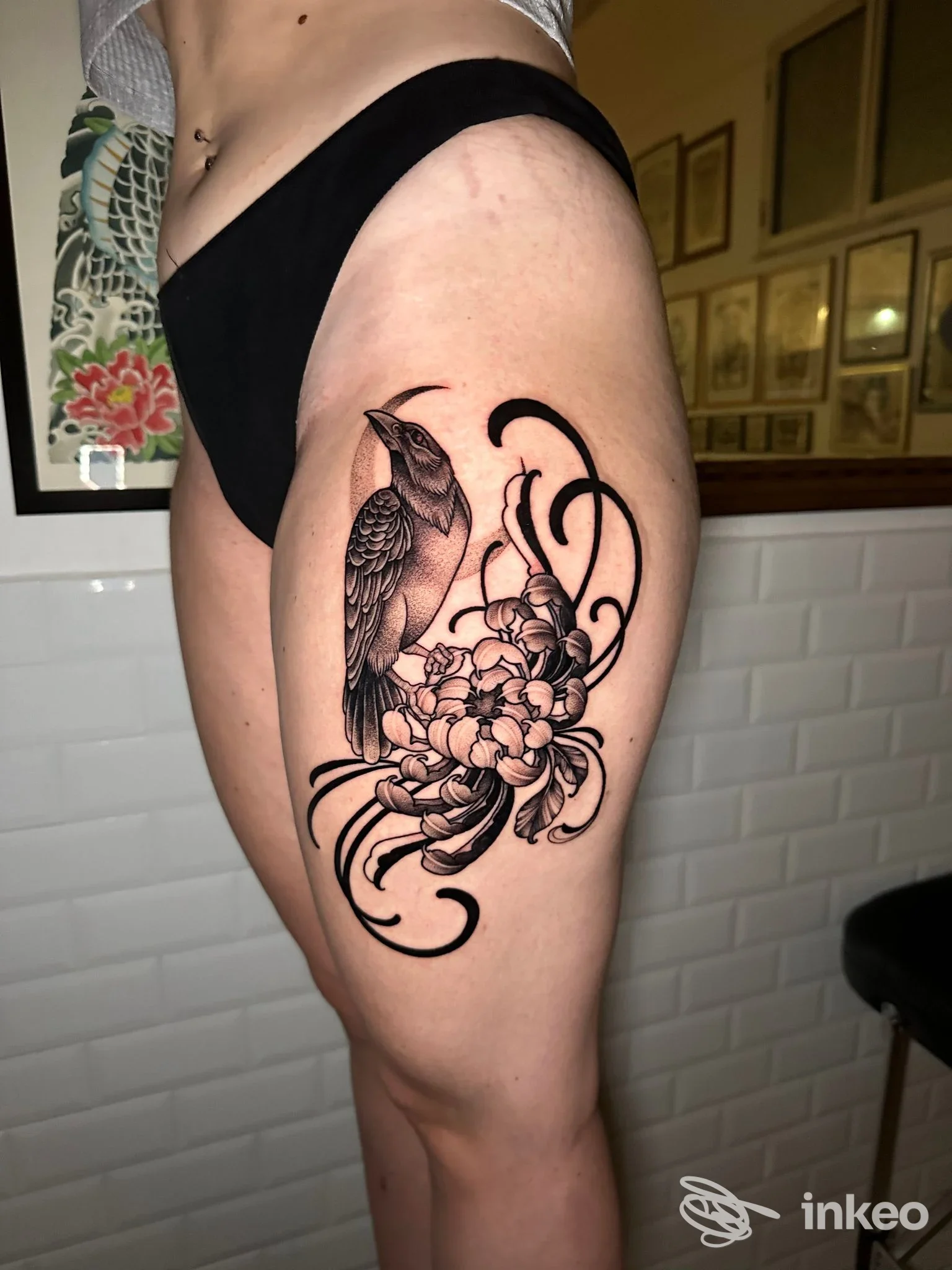Tatuaggio in nero e grigio su coscia con uccello e fiori, fotografia del lavoro eseguito da Blacktop Tattoo Club a Palermo.