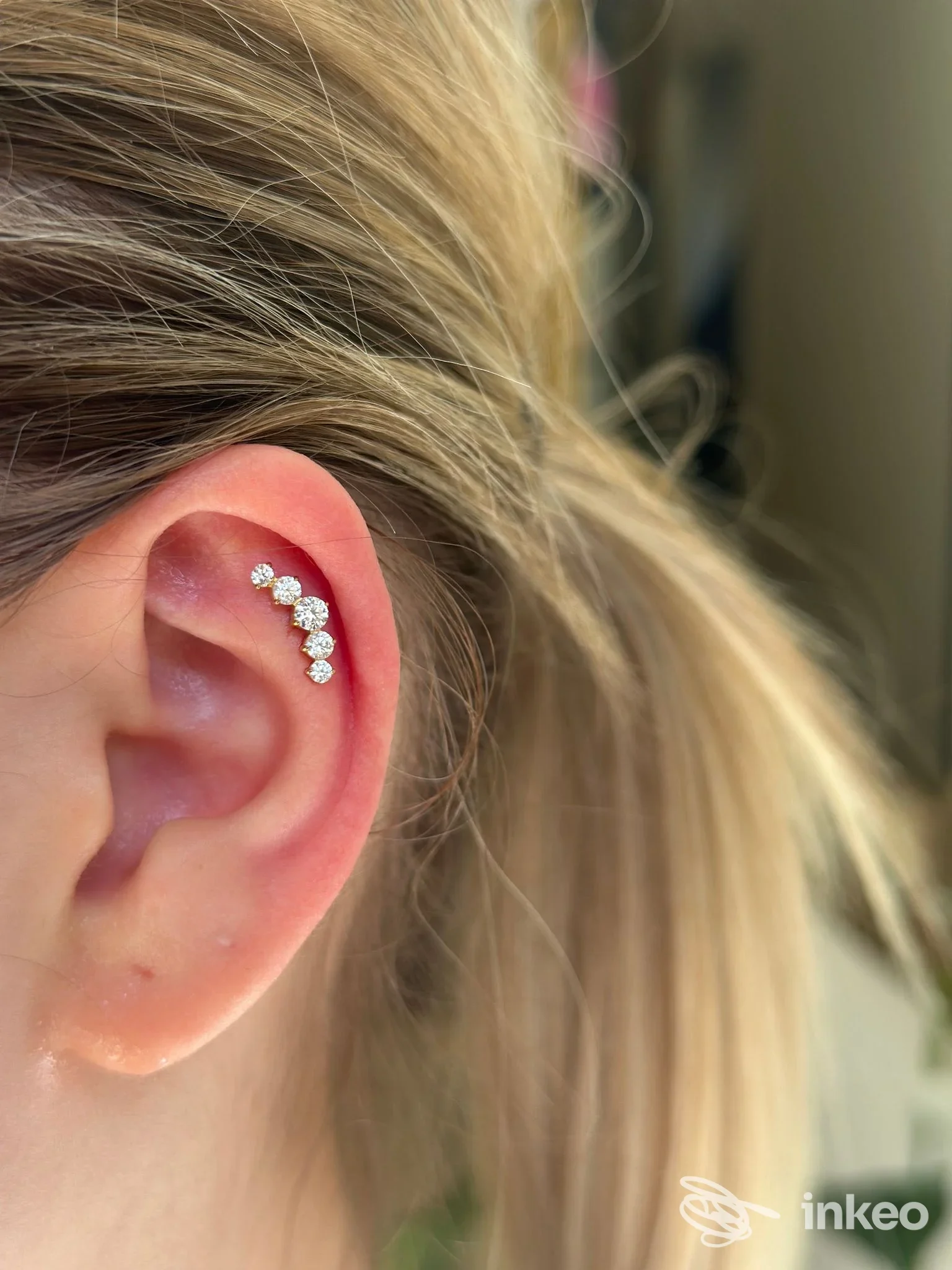 Orecchio con piercing a più gemme sulla elice, foto di FLO TATTOO ART, Mazara del Vallo.