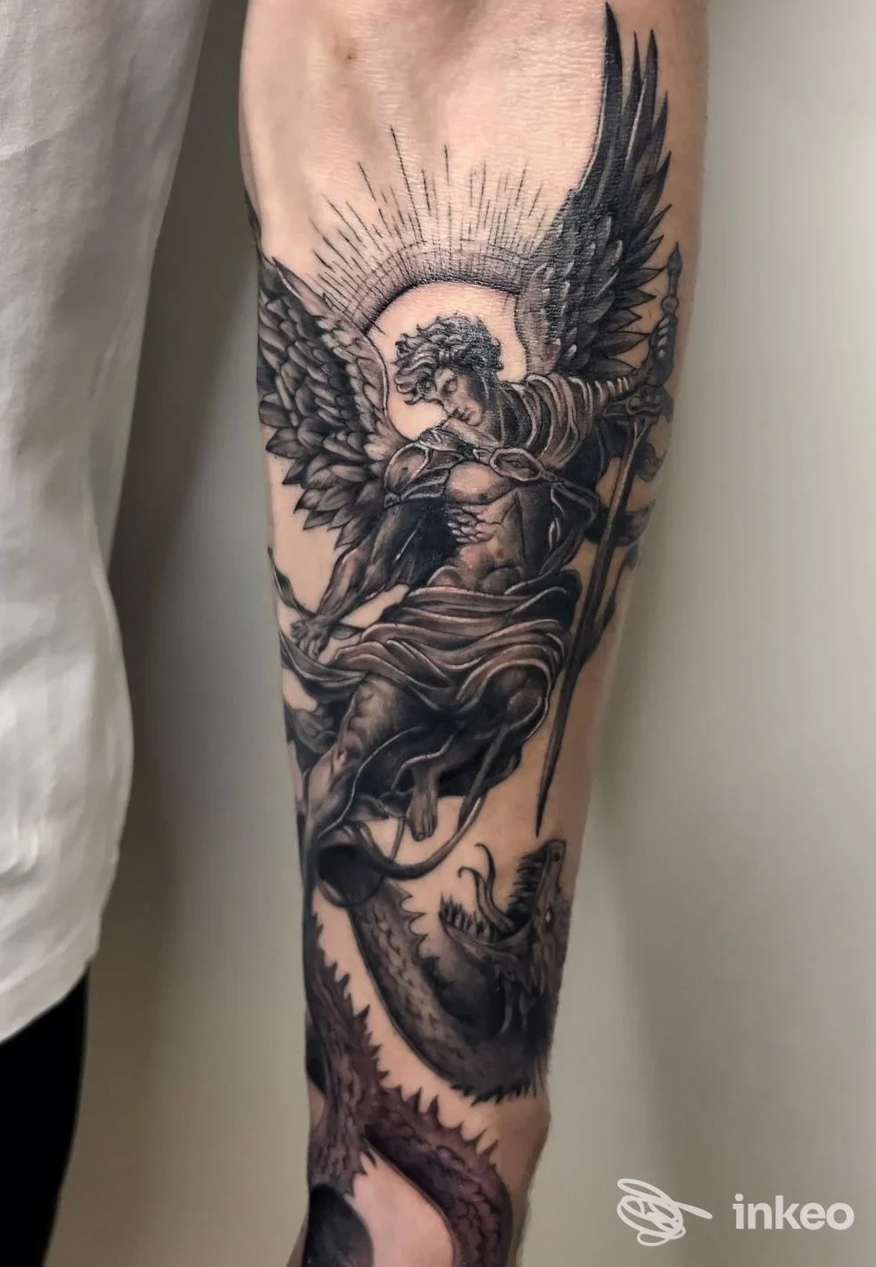 Tatuaggio black & grey su avambraccio raffigurante un angelo alato; immagine fornita da Gale Tattoo Studio, Caltanissetta.