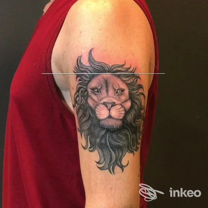 Tatuaggio realistico di leone in bianco e nero sul braccio superiore, eseguito da Cocostudio 117 TATTOO a Trapani, dettaglio della chioma e del muso.