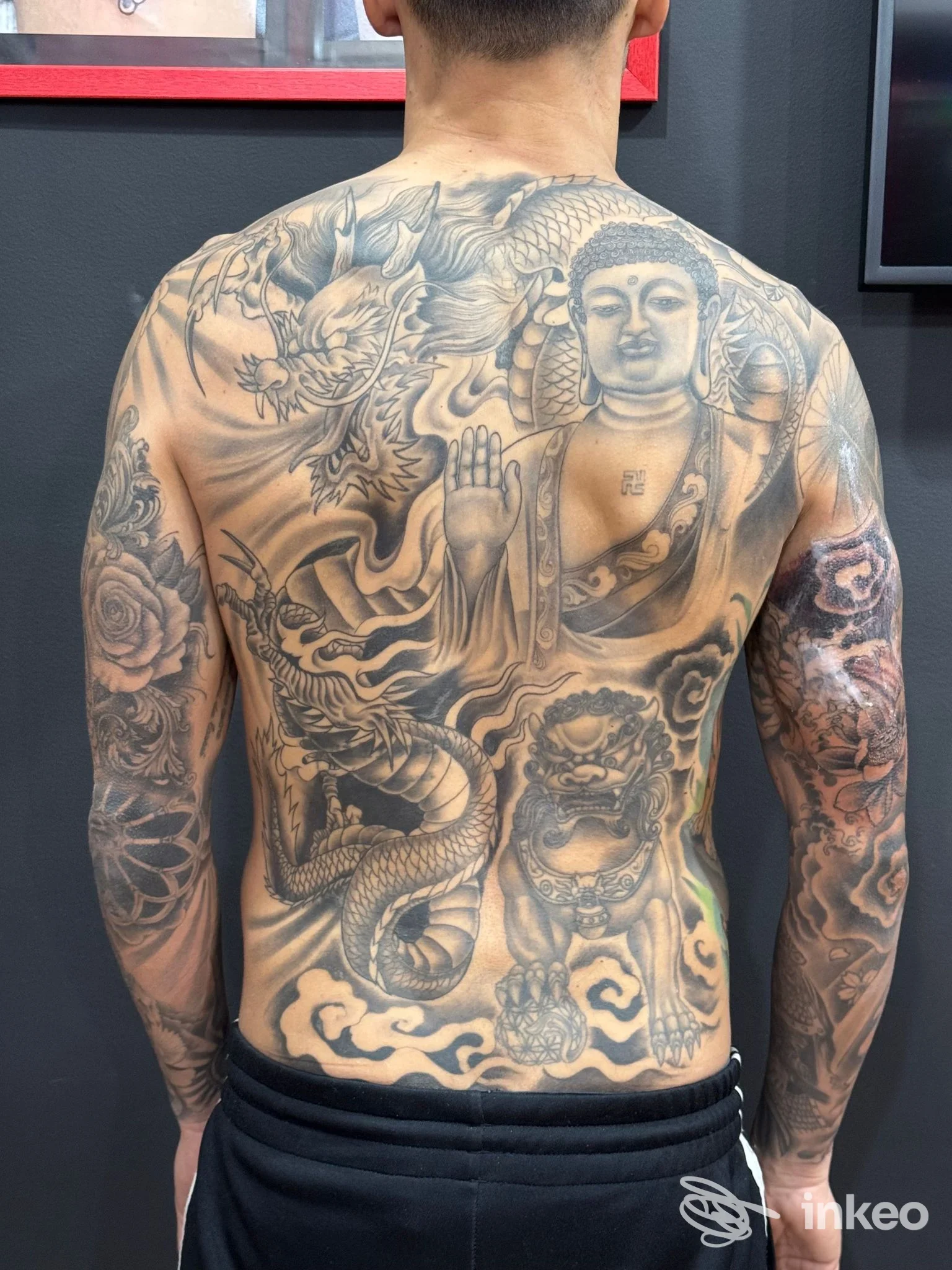 Ampia schiena tatuata con Buddha e drago in bianco e nero, foto fornita da Del Popolo Tattoo a Messina.