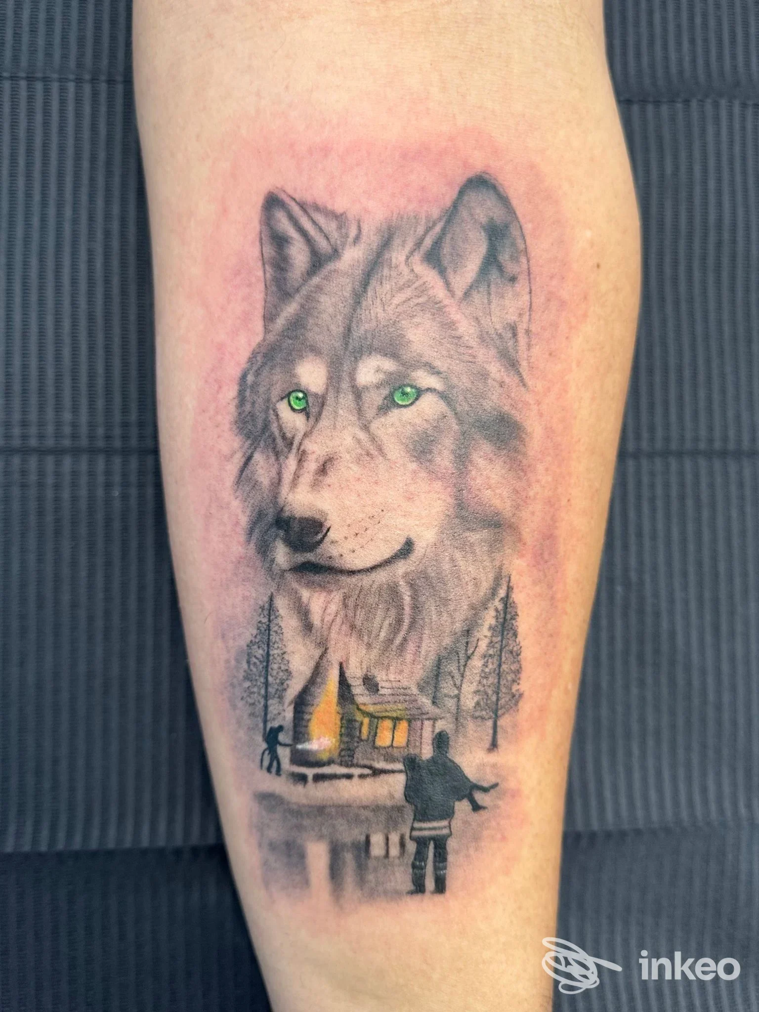 Tatuaggio su avambraccio di un lupo con occhi verdi e piccola scena sottostante, foto inviata da Fily art tattoo a Marsala.