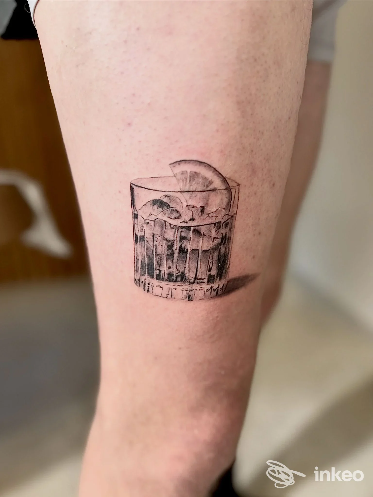 Tatuaggio su coscia: bicchiere con ghiaccio e fetta di limone, realizzato da Fily art tattoo a Marsala.