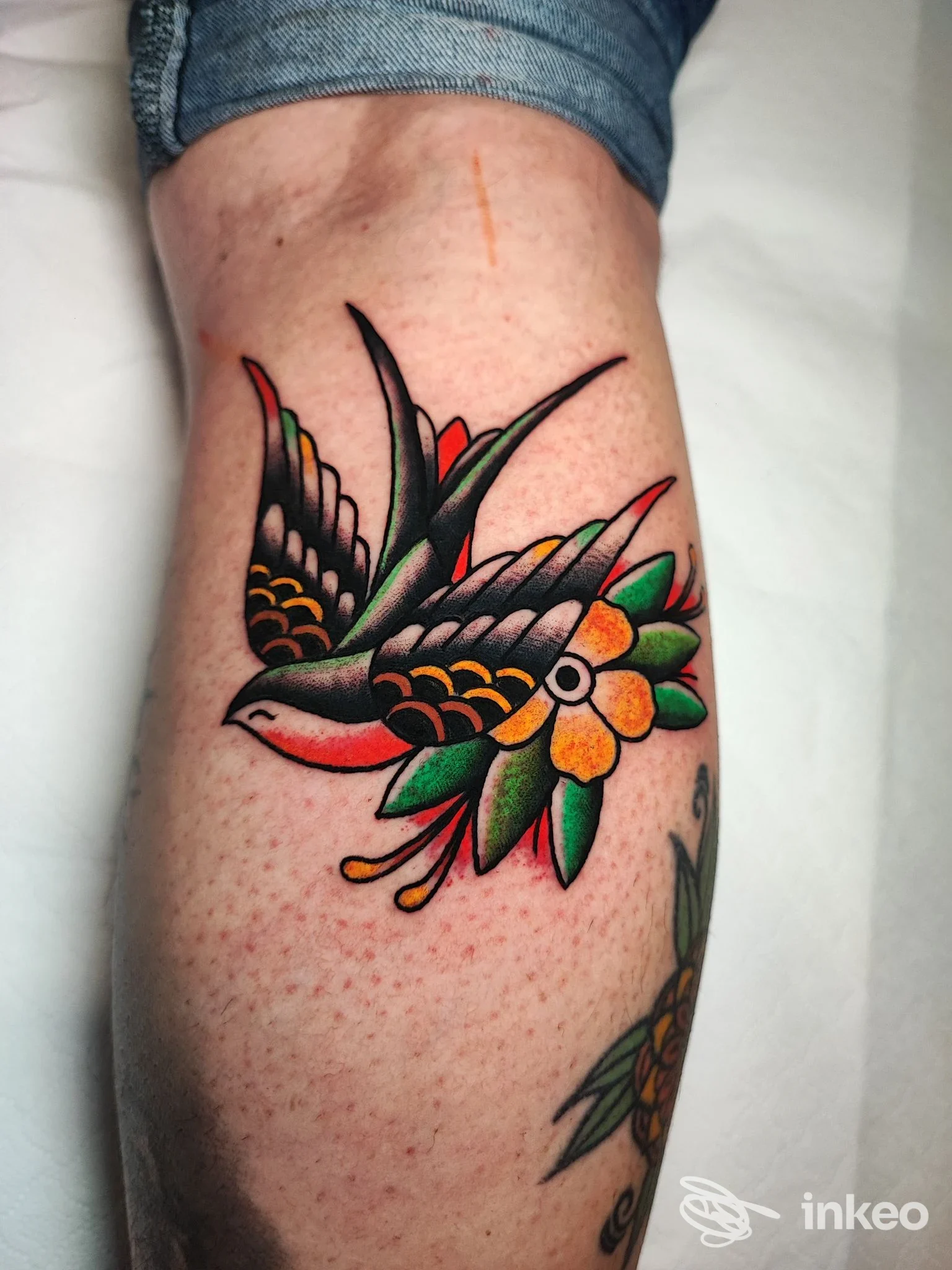 Tatuaggio tradizionale di rondine e fiori sul polpaccio, G. COX TATTOO, Catania.