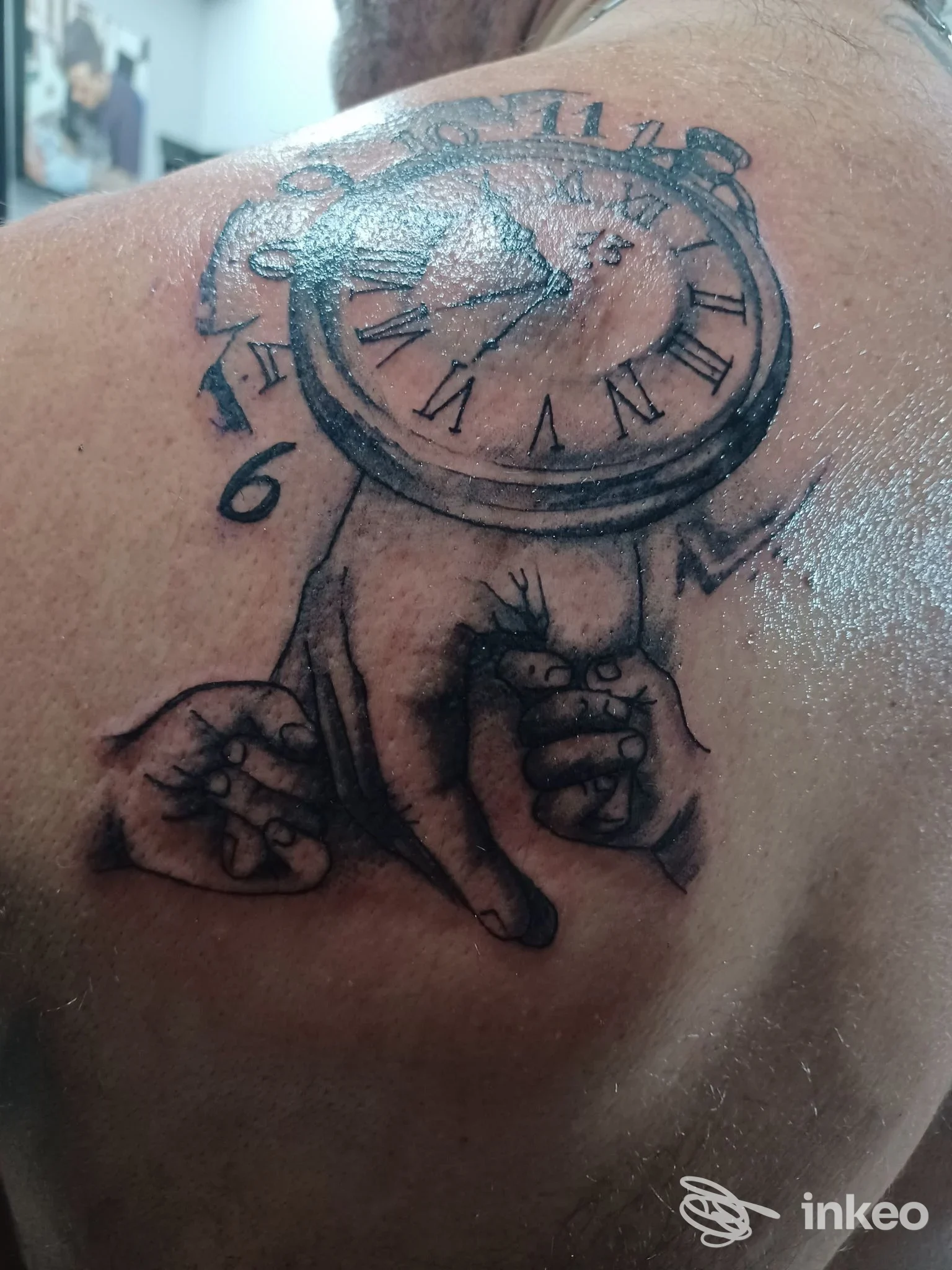 Tatuaggio in bianco e nero raffigurante un orologio e mani sul deltoide/posteriore della spalla, realizzato da Giupy Tattoo a Palermo.