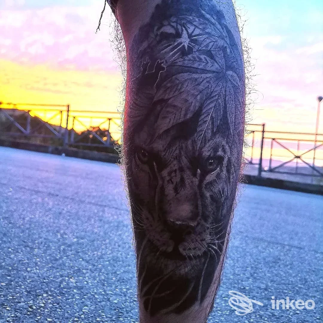 Tatuaggio realistico in bianco e nero di una testa di tigre sul polpaccio, foto all'aperto al tramonto. GR SKIN INK, Caltagirone.