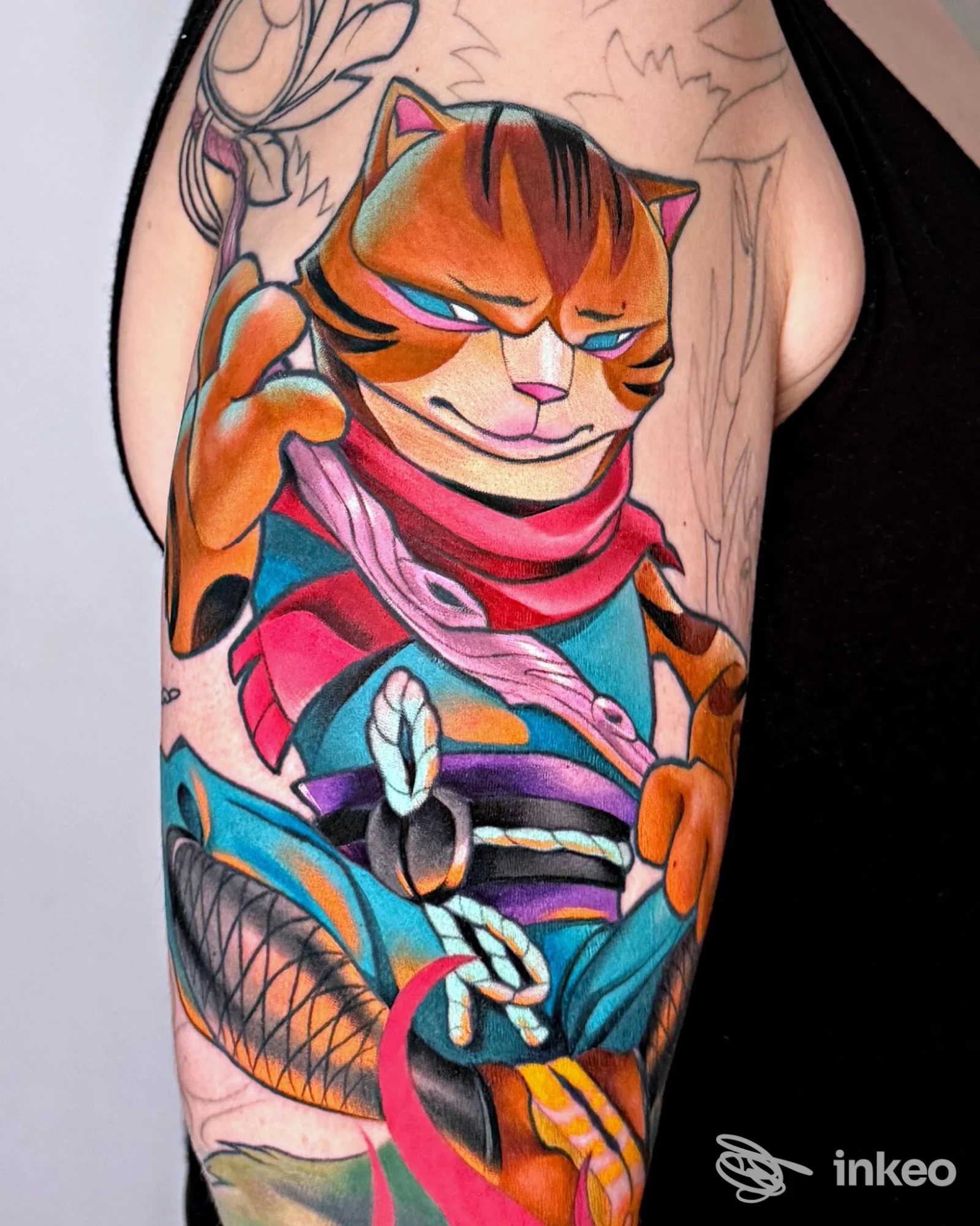 Tatuaggio colorato su braccio superiore raffigurante un gatto stilizzato, lavoro eseguito da Garage Tattoo a Catania.