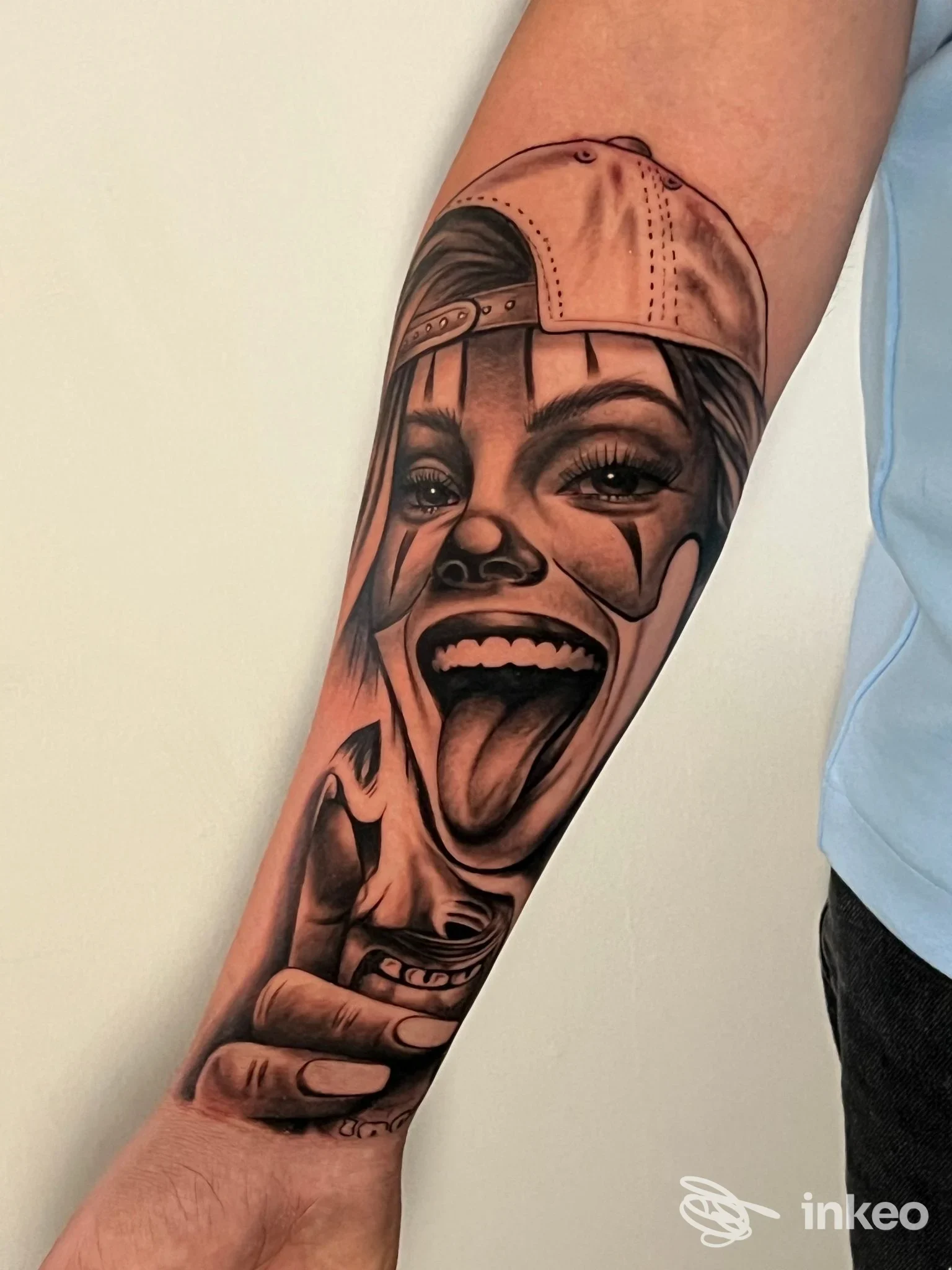 Tatuaggio realistico a tinta nera sull'avambraccio, volto clown sorridente; Ghost Lost tattoo shop, Bagheria.